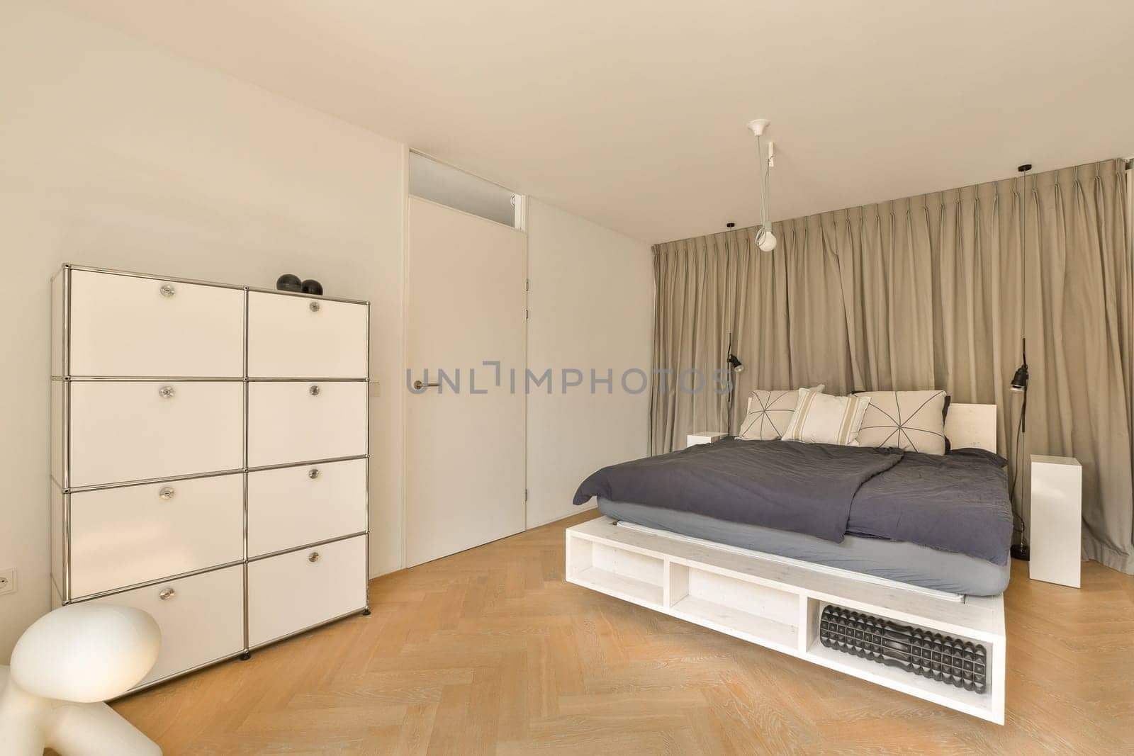 a bedroom with a bed, dressers and cupboards in the same color as they appear on the floor