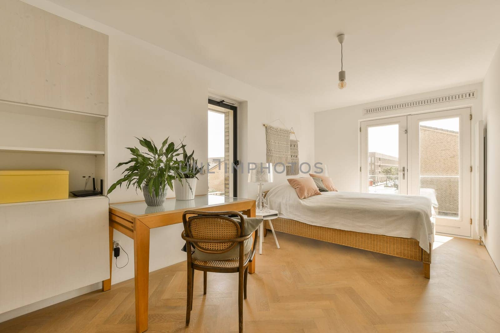 a bedroom with a bed, desk and chair in the corner next to an open window that looks out onto the street