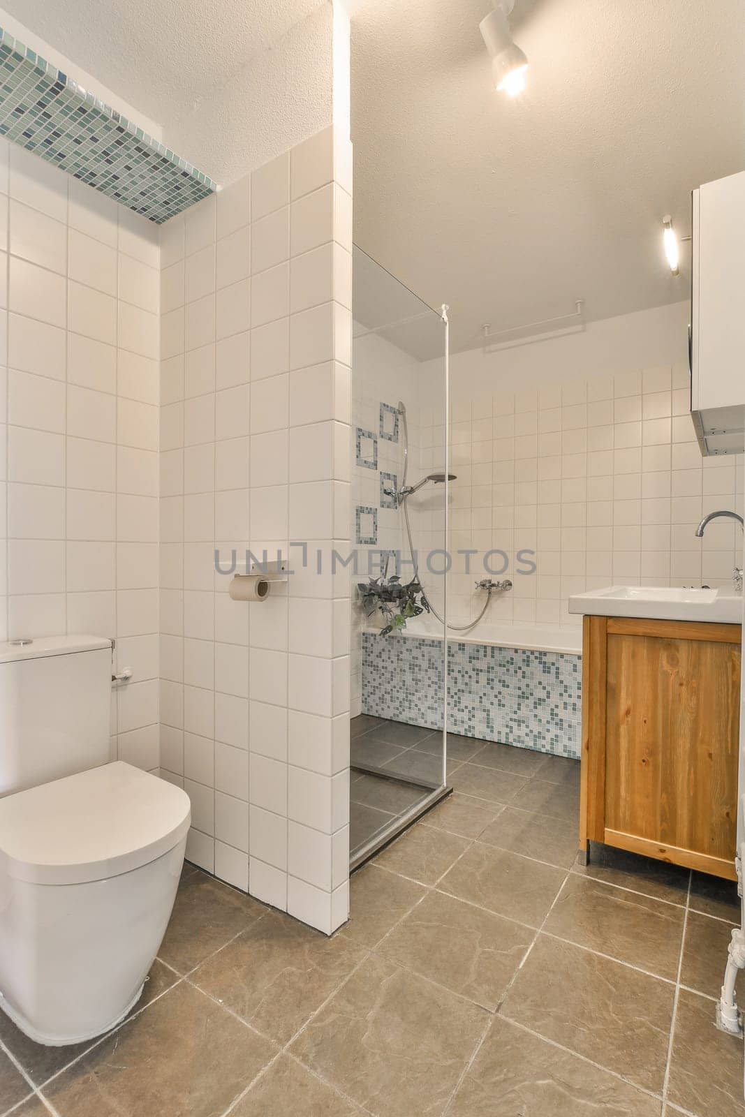 a bathroom with tile flooring and white tiles on the walls, along with a wooden vanity in the corner