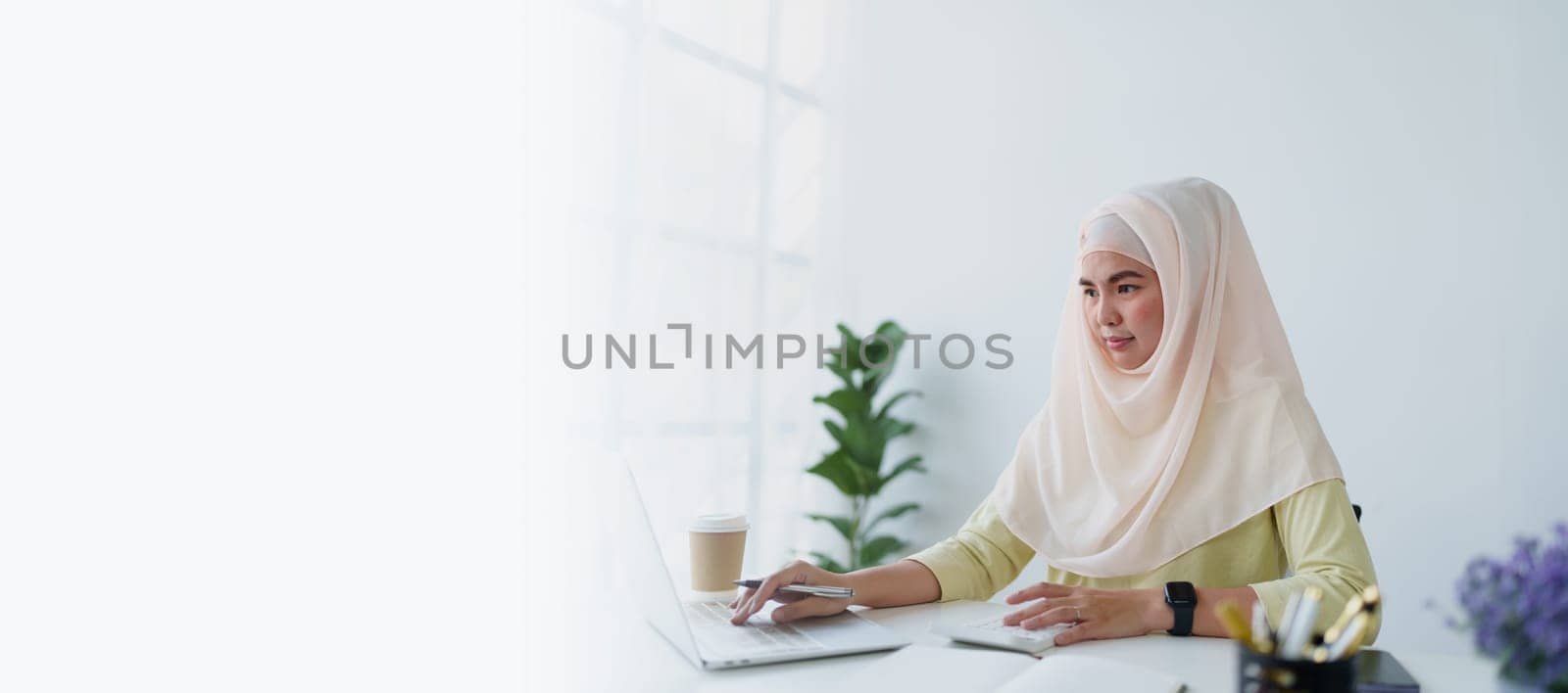 Muslim women use calculators, computers, and laptops to check their accounts at work