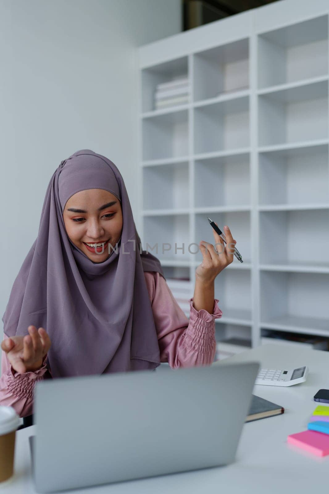 Muslim female employee Conferencing via computer during work. by Manastrong