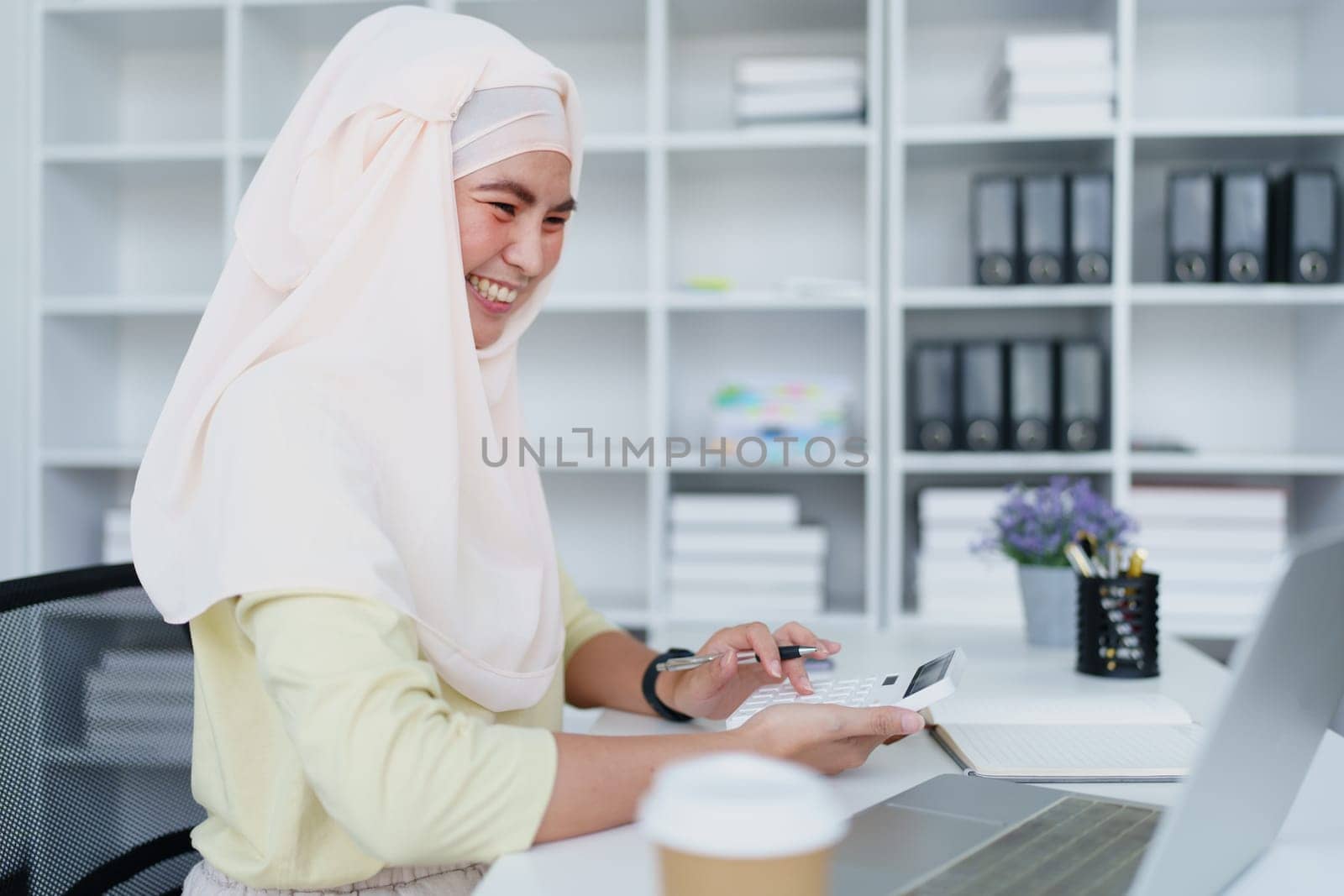 Muslim women use calculators, computers, and laptops to check their accounts at work. by Manastrong