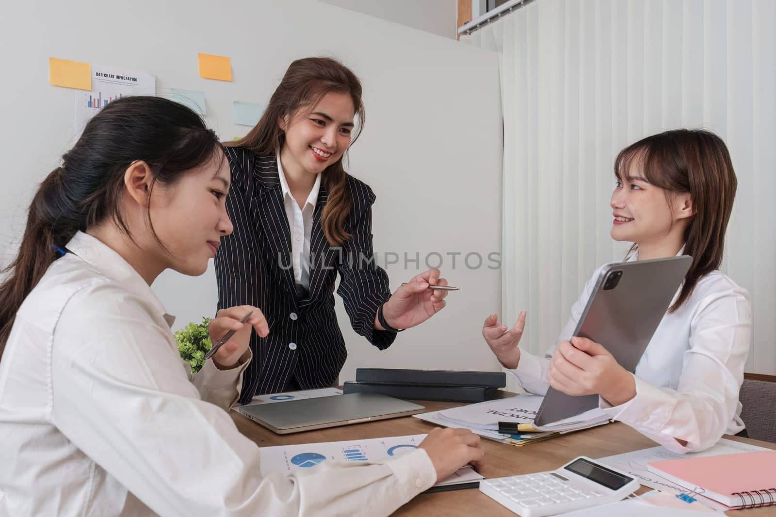 Business People Meeting using laptop computer,calculator,notebook,stock market chart paper for analysis Plans to improve quality next month. Conference Discussion Corporate Concept..