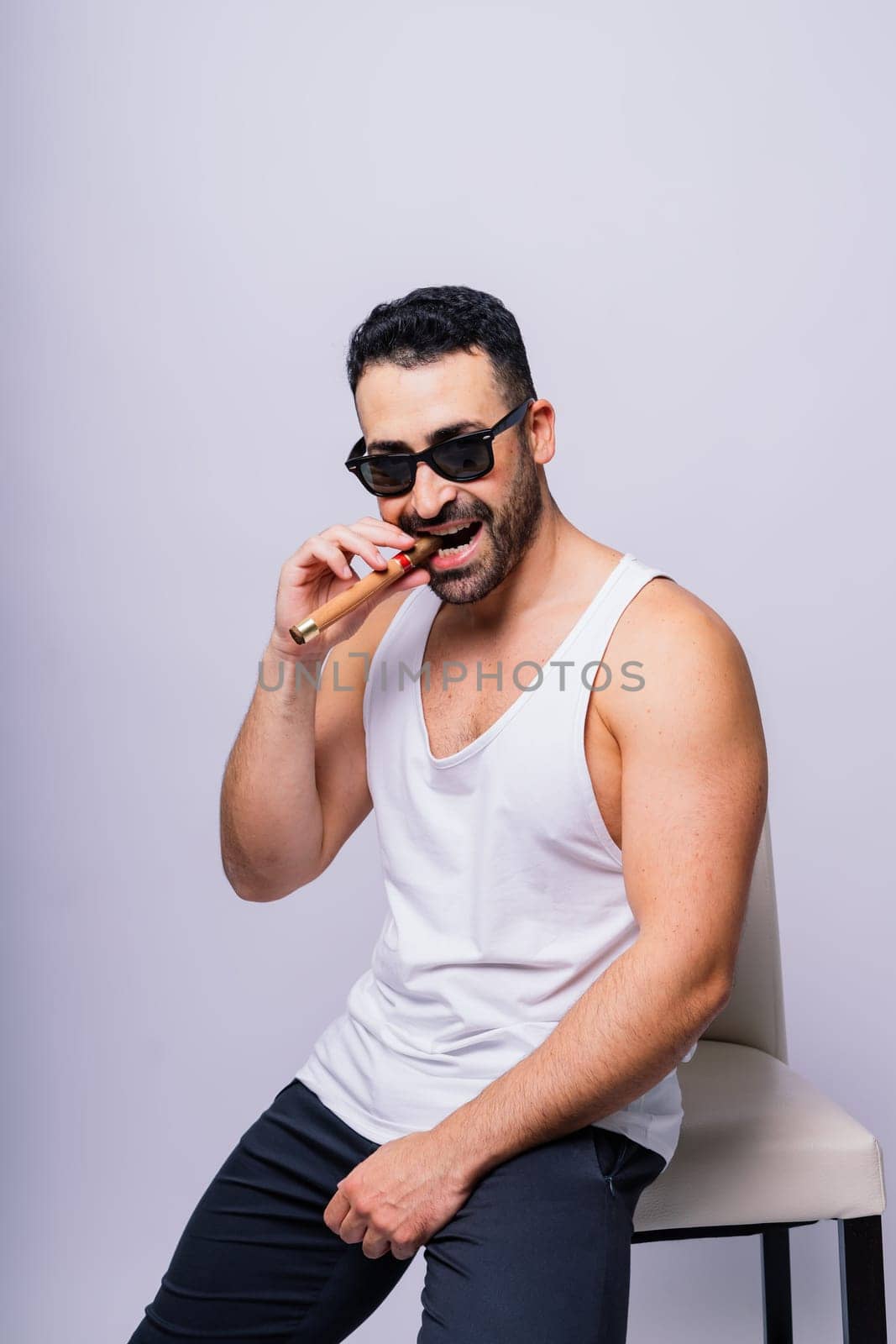 Close-up bearded caucasian man smoking cigar. Wearing white shirt. Studio portrait