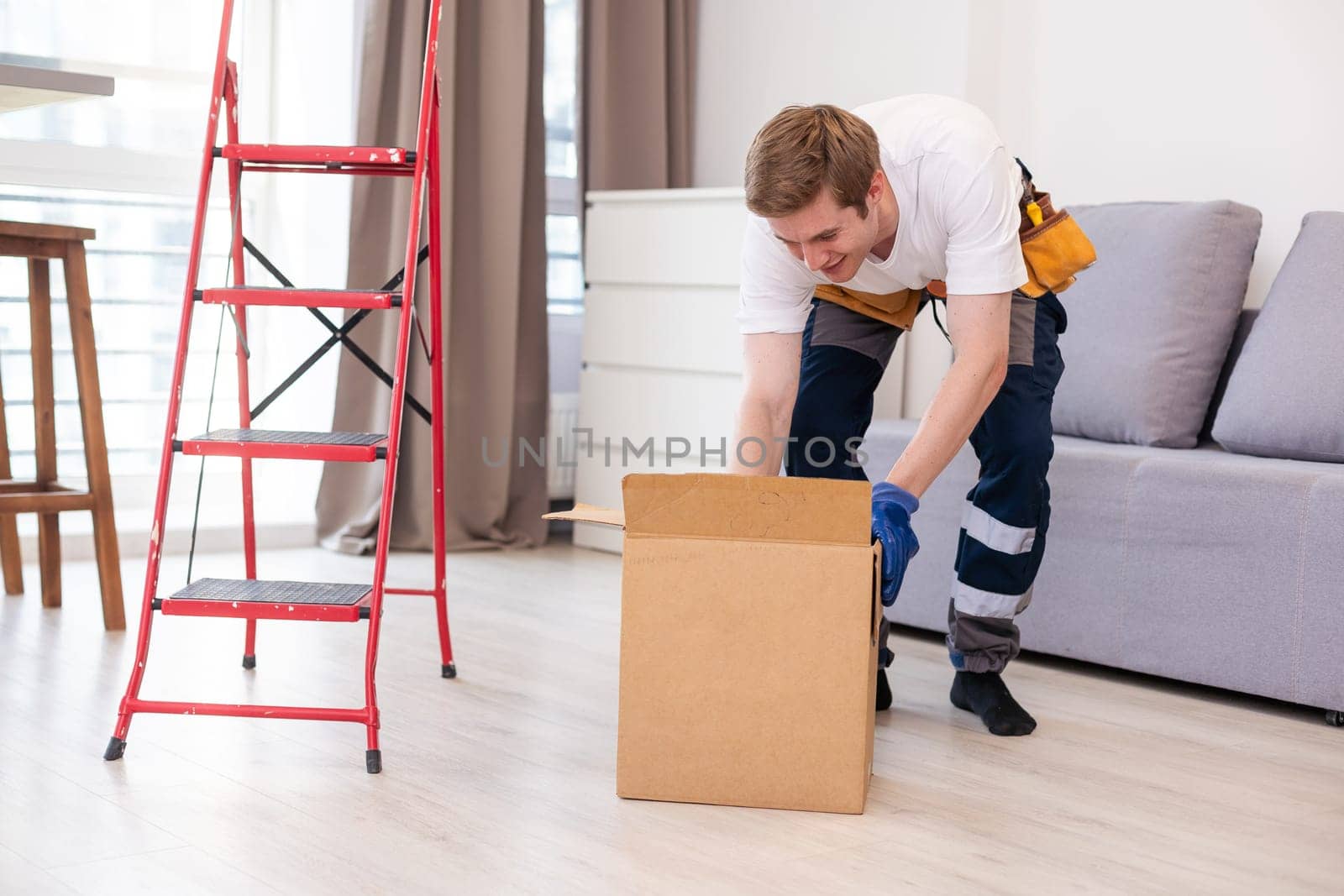 moving, people and real estate concept - happy smiling man holding boxes with stuff at new home.