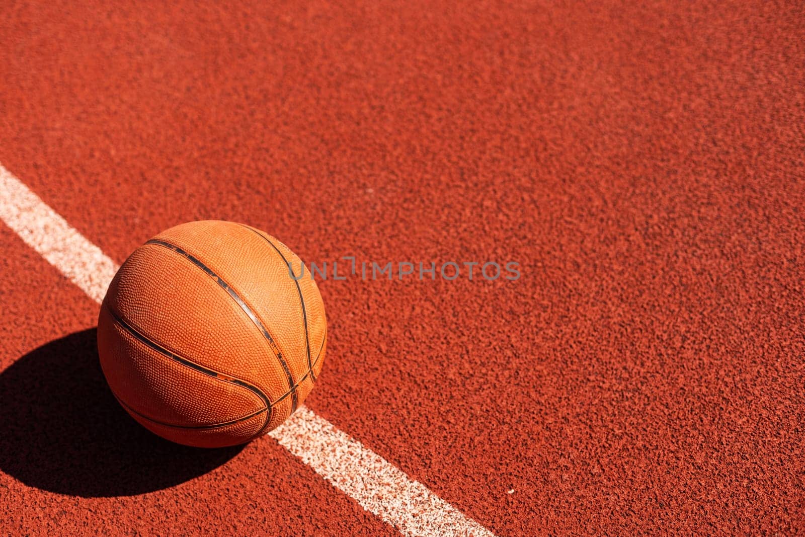 Basketball on Court Floor close up with blurred arena in background. by Andelov13