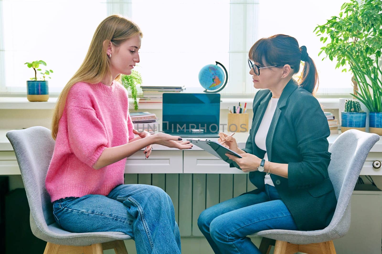 Counselor with clipboard talking with teenage girl by VH-studio