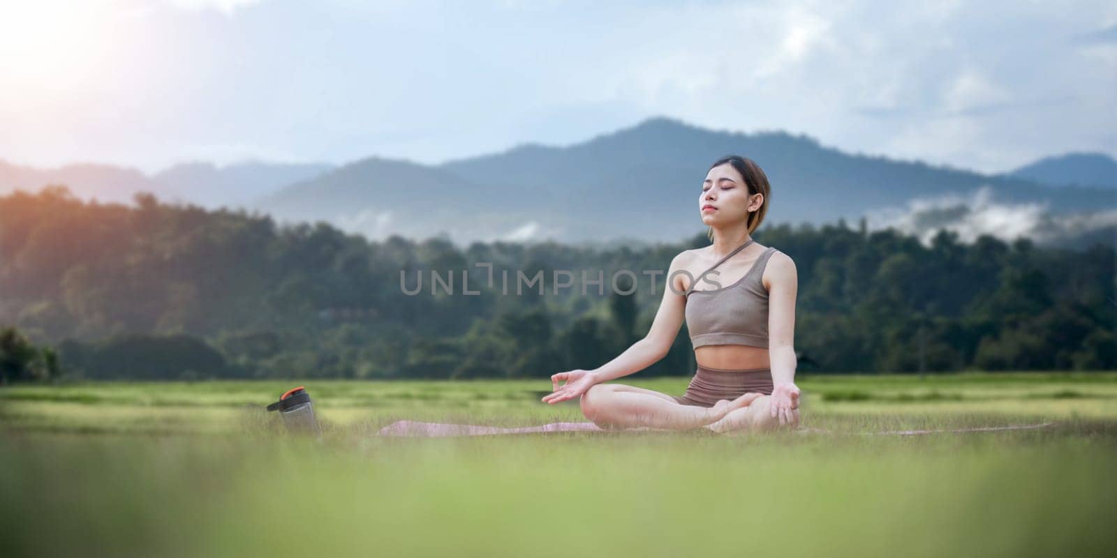 Asian woman on fitness mat, sporty lady practicing yoga at public park outdoor, stretching her body. Healthy active lifestyle by nateemee