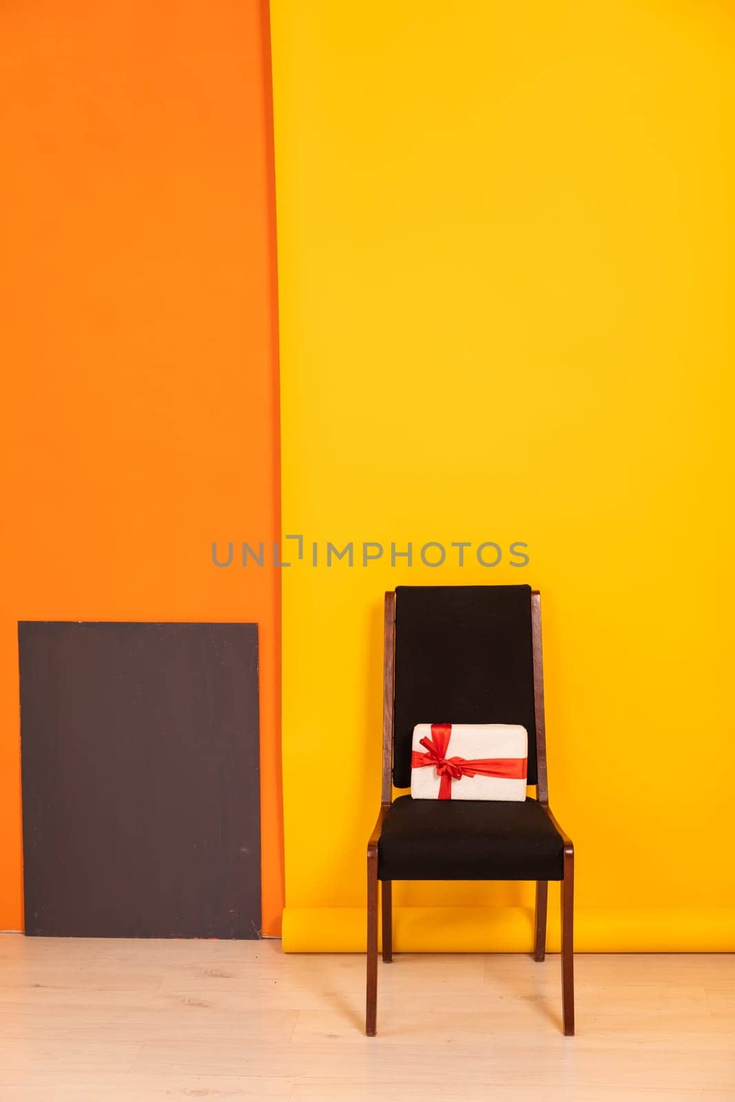 Vintage chair with gift in interior on yellow background by Simakov