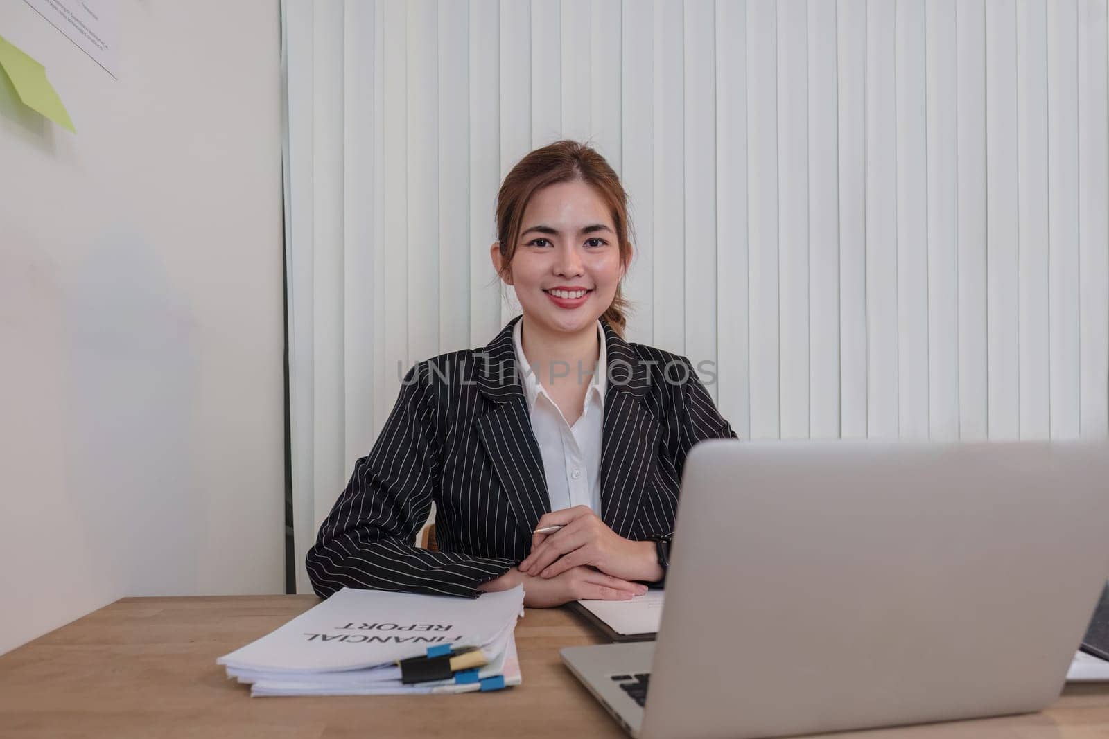Portrait of an Asian young business Female working on a laptop computer in her workstation. Business people employee freelance online report marketing e-commerce telemarketing concept..