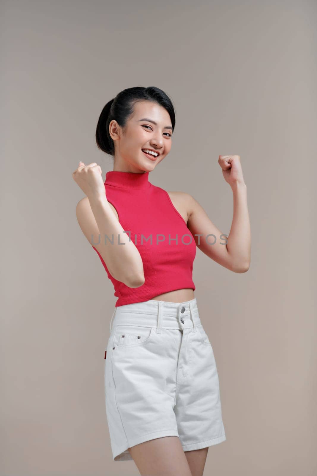 Emotional asian girl expressing amazement over beige studio background by makidotvn