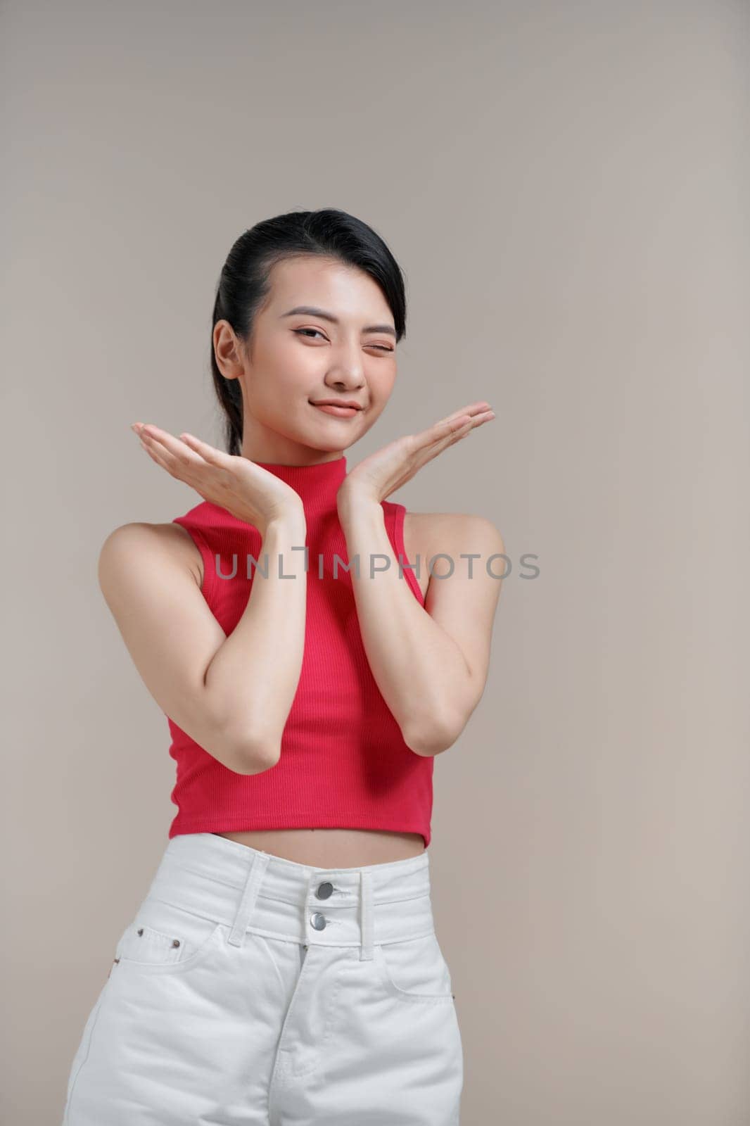 Happy dreamy young asian woman holding hands near head, being concentrated on pleasant thoughts, smiling,