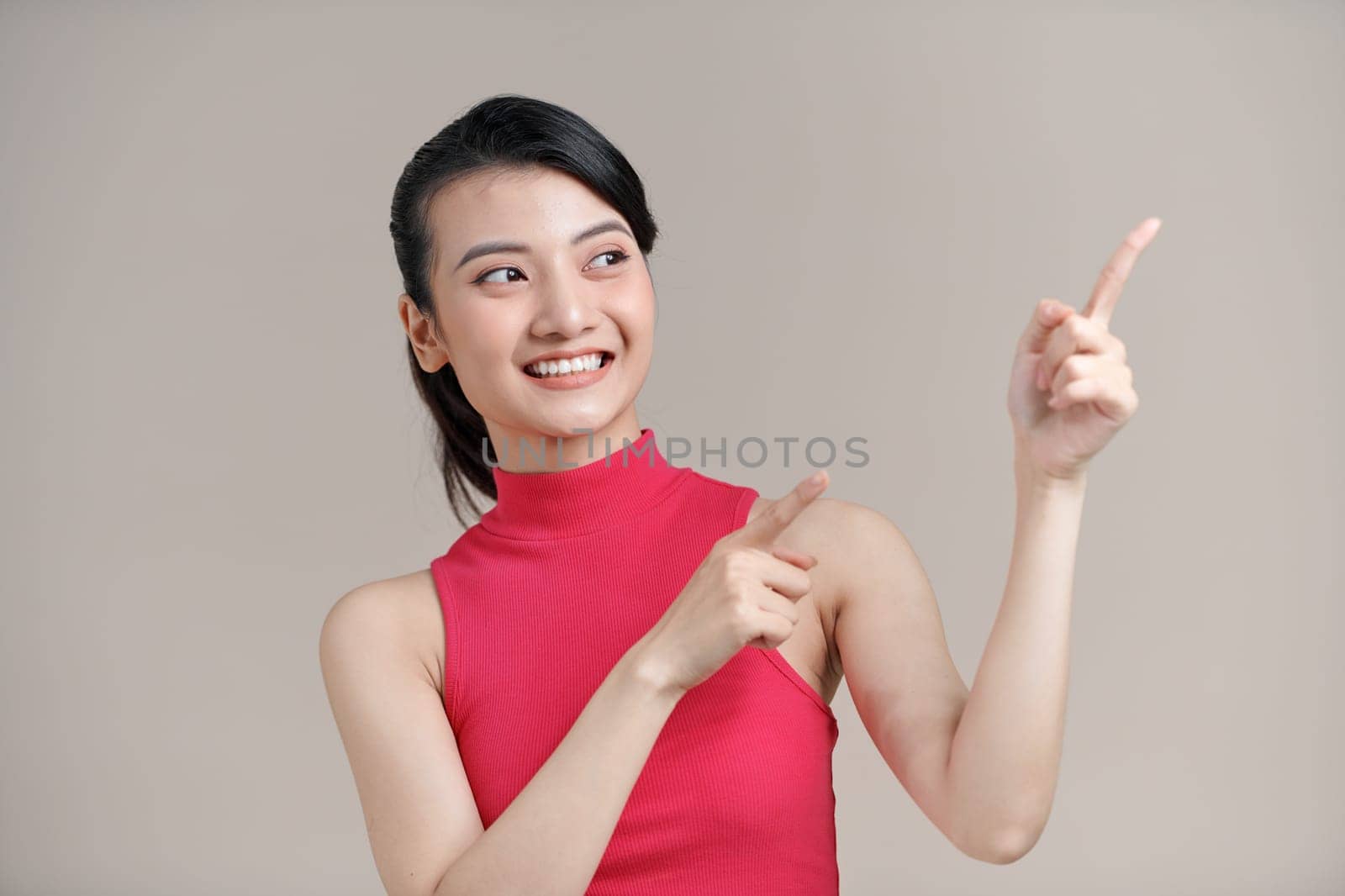 Young beautiful woman smiling and pointing with two hands and fingers to the side.