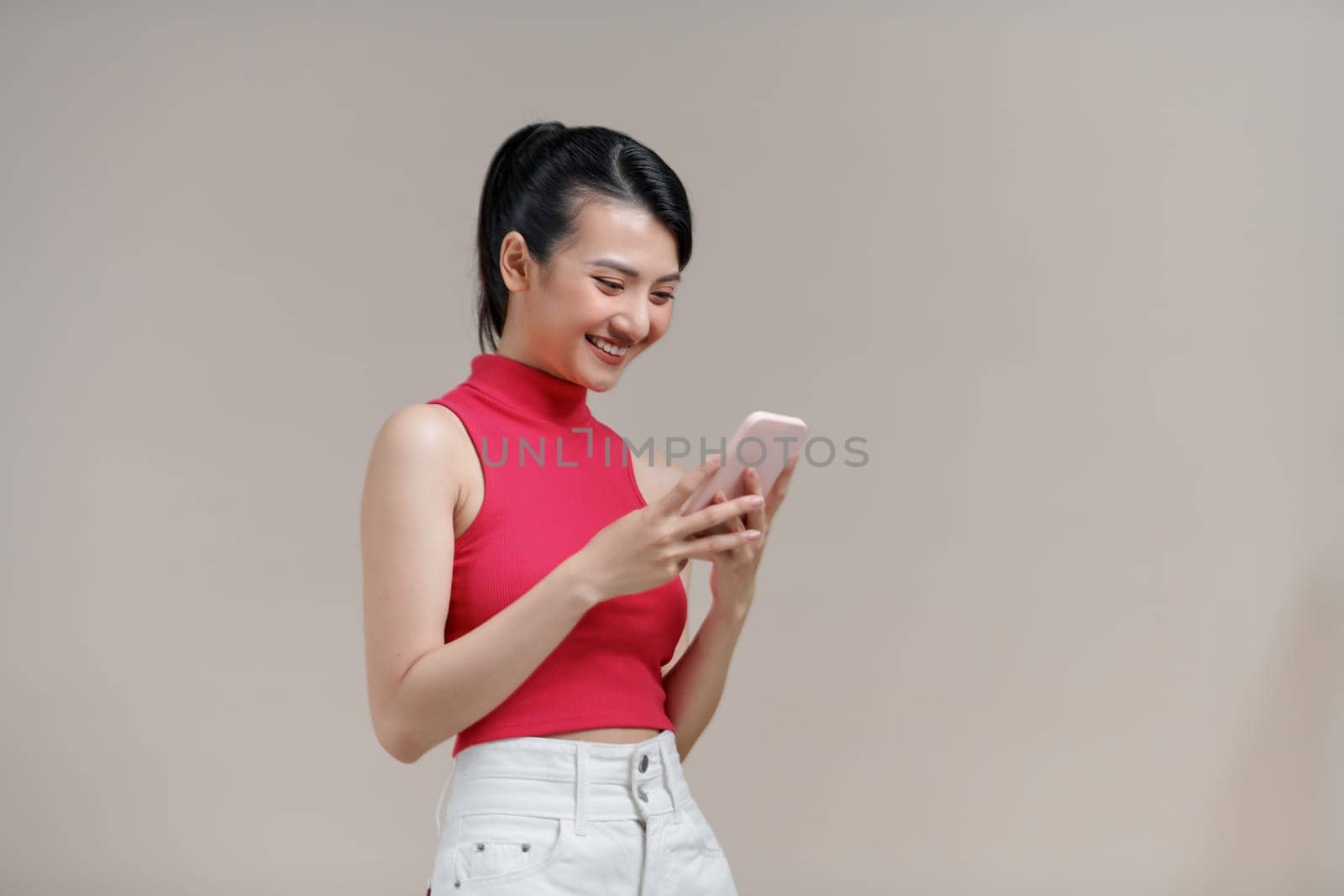 Happy asian woman feeling happiness and standing typing smartphone by makidotvn