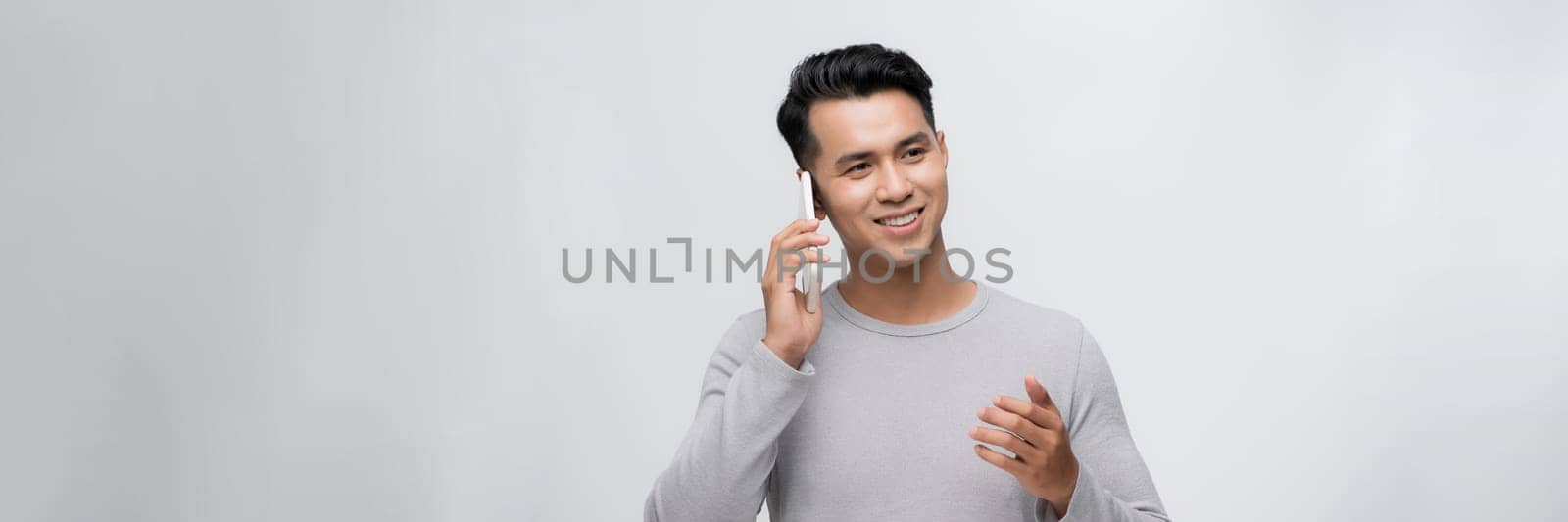 Attractive young man with smartphone on color background by makidotvn