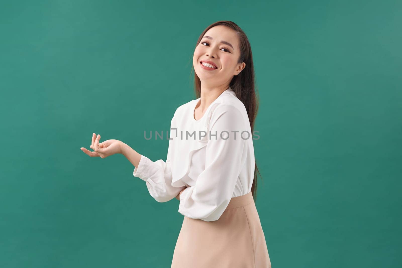 Asian female model smiling looking up.woman pointing fingers away on white background isolated.
