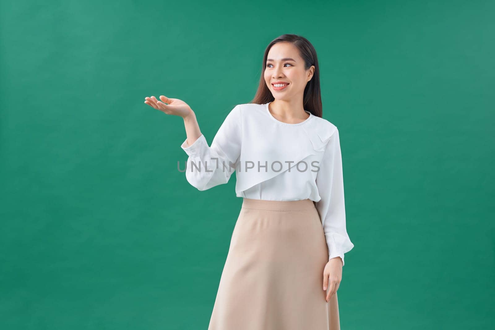 Asian female model smiling looking up.woman pointing fingers away on white background isolated. by makidotvn