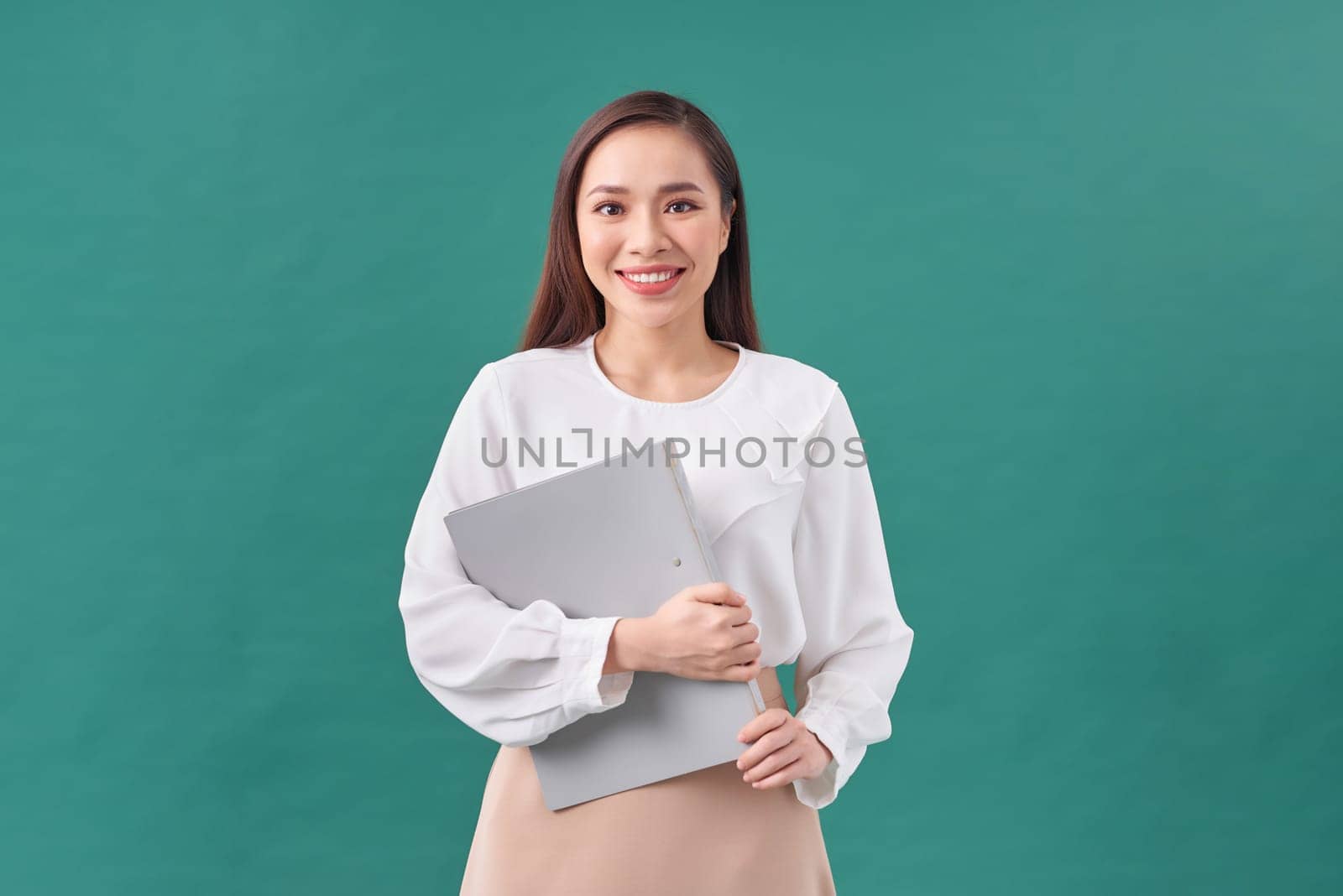 Portrait of a happy asian businesswoman holding clipboard isolated over green background by makidotvn