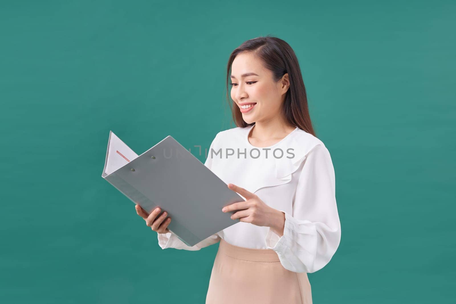 Attractive young asian woman hold clipboard with papers document writing on green background by makidotvn