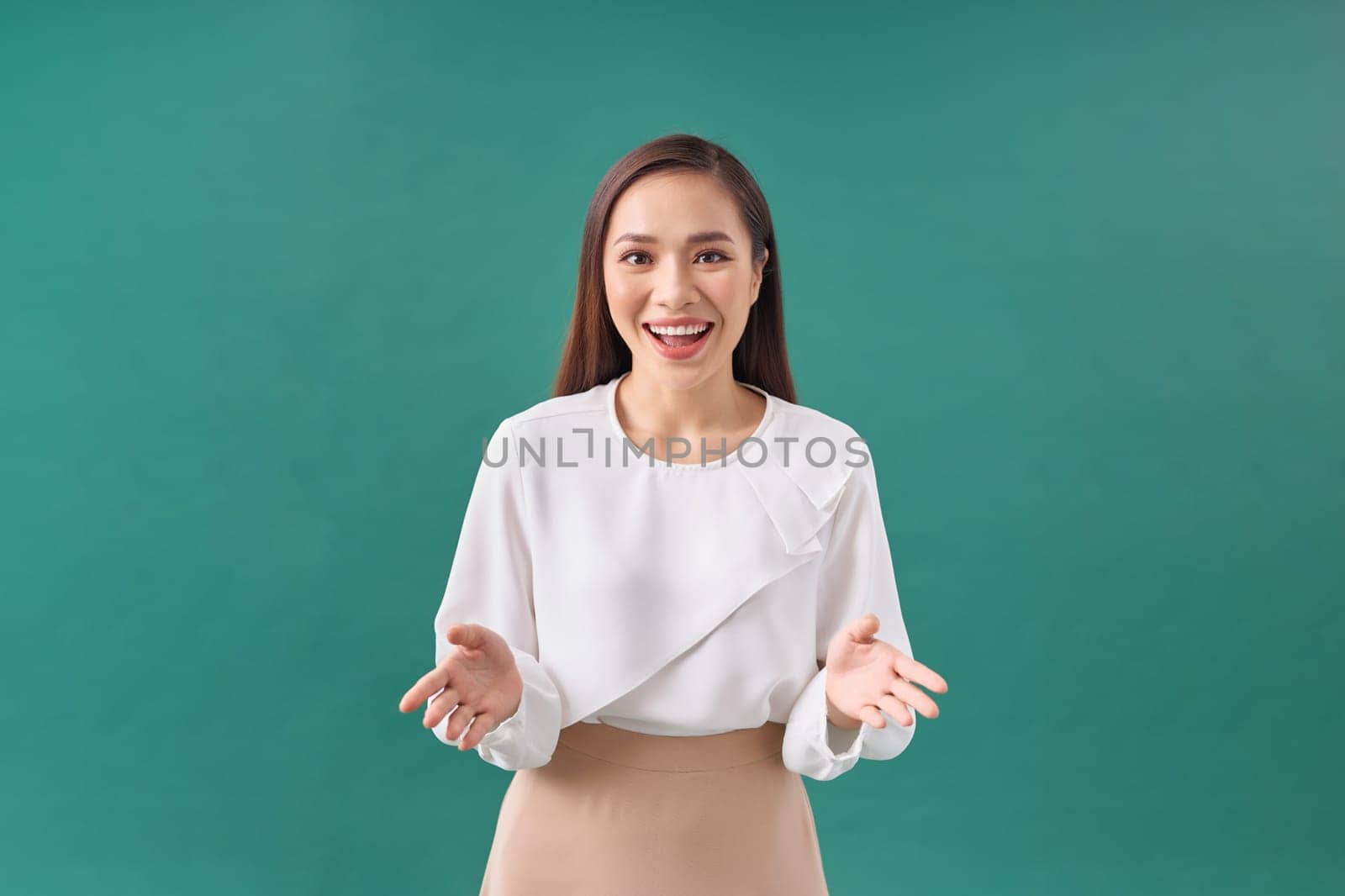 businesswoman stretching out open hands, greeting, standing over green background