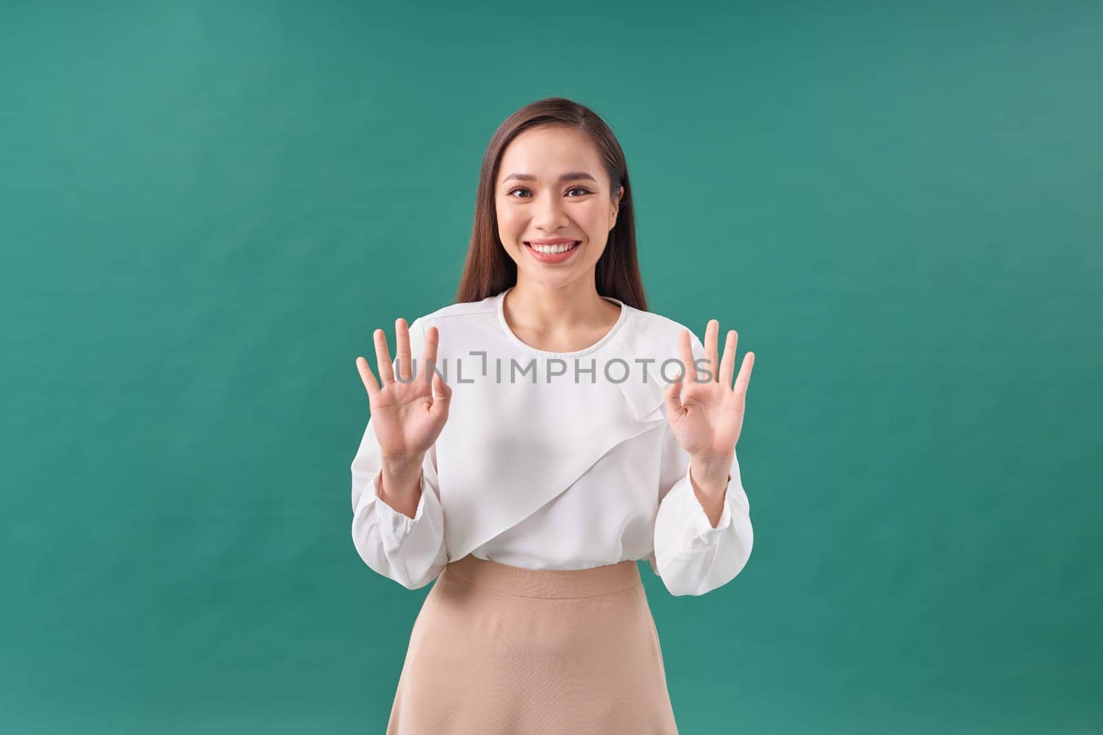 Portrait of a young happy woman showing open hand and five fingers