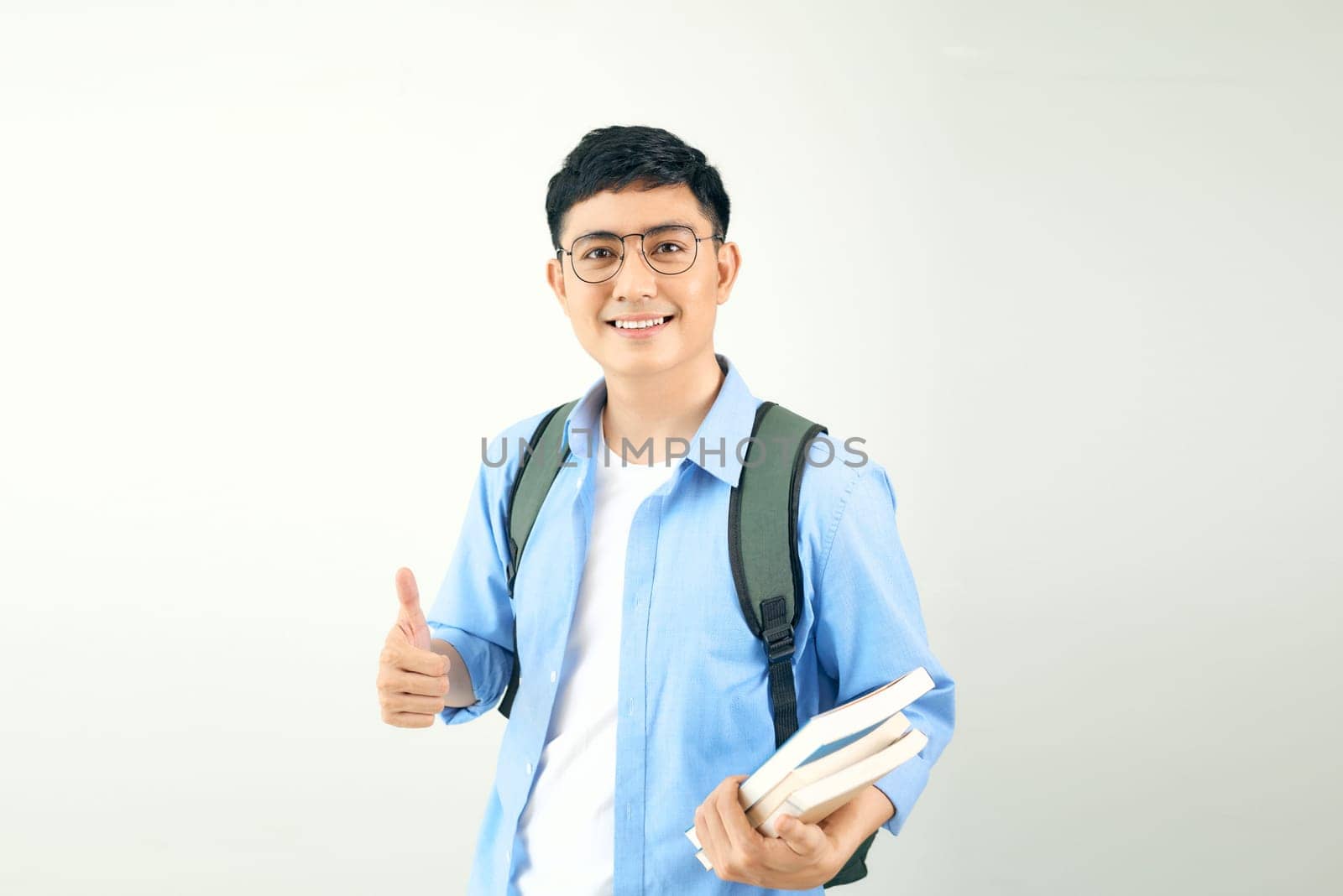 Smiling young man student with backpack hold books isolated on white background. by makidotvn