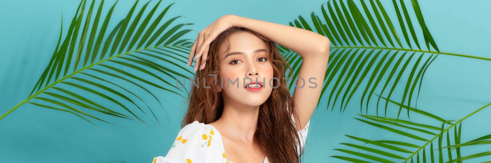 Pretty lady in a yellow dress and green leaves of trees on blue banner