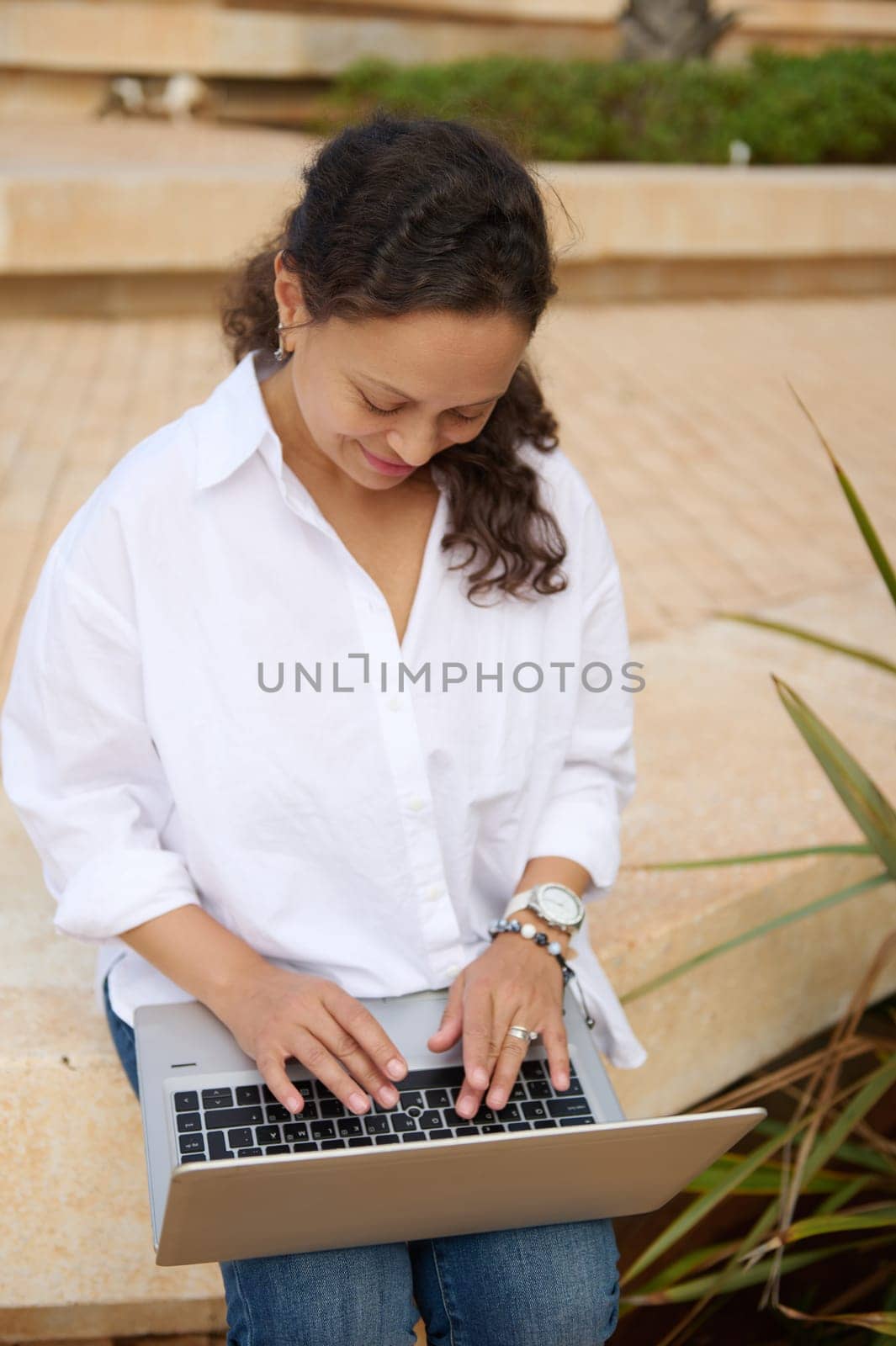 Portrait of a successful happy smiling female entrepreneur, young adult business woman in casual attire, remotely working on laptop computer, planning startup project. People. Real estate investment