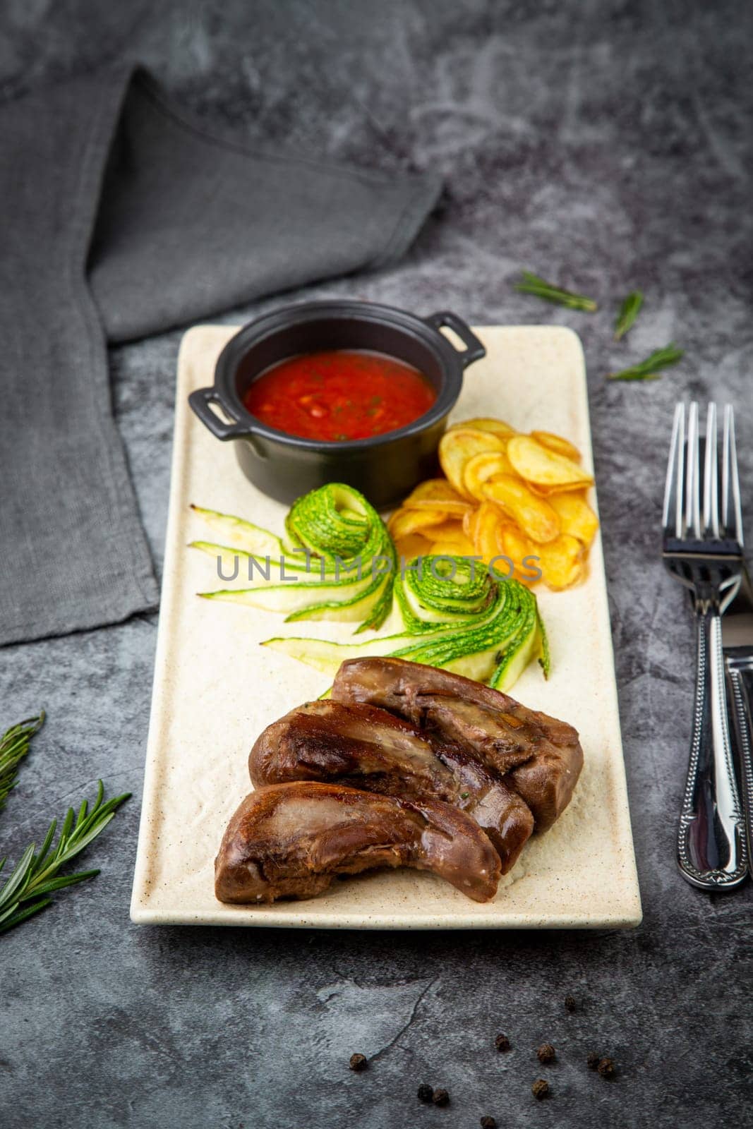 meat ribs with avocado, chips and ketchup on a white plate