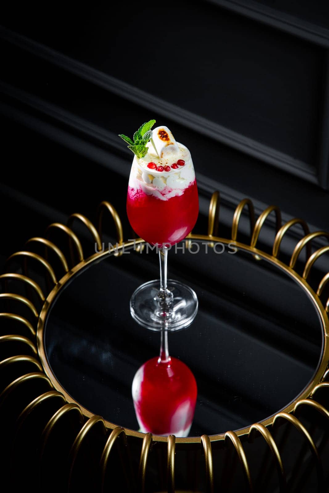 red cocktail with whipped cream instead of topping and mint leaves, side view by tewolf