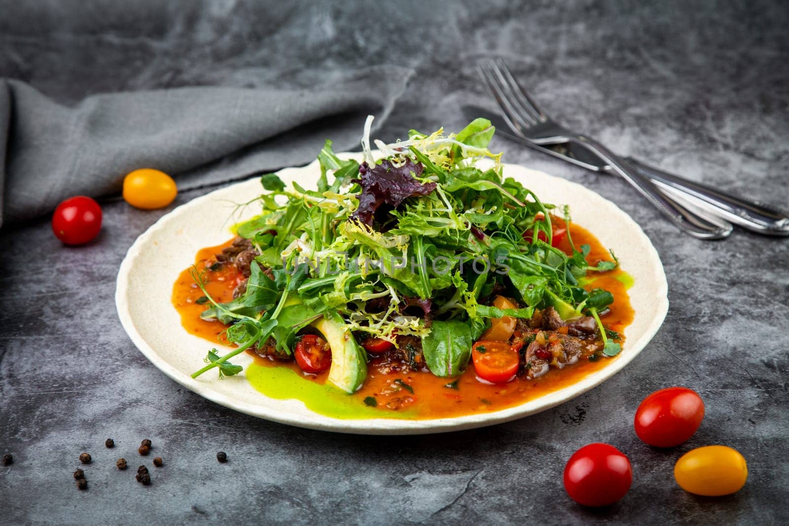 meat gravy with meat, cherry tomatoes and a bunch of greens on top, side view by tewolf