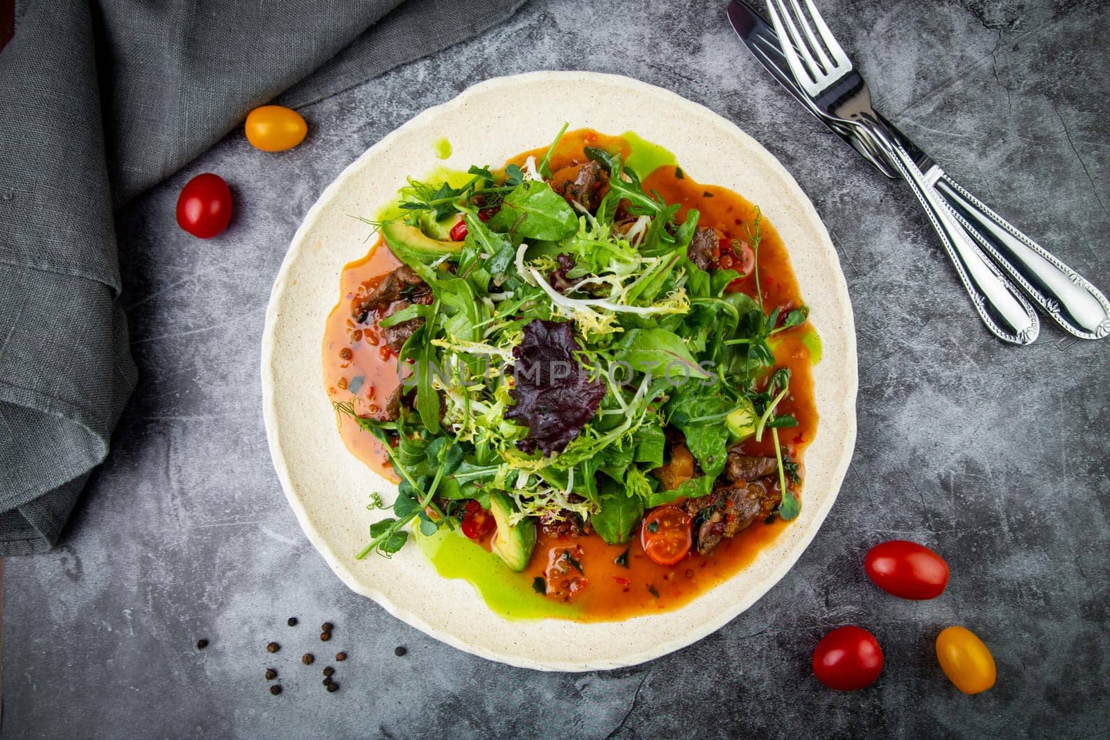 meat gravy with meat, cherry tomatoes and a bunch of greens on top