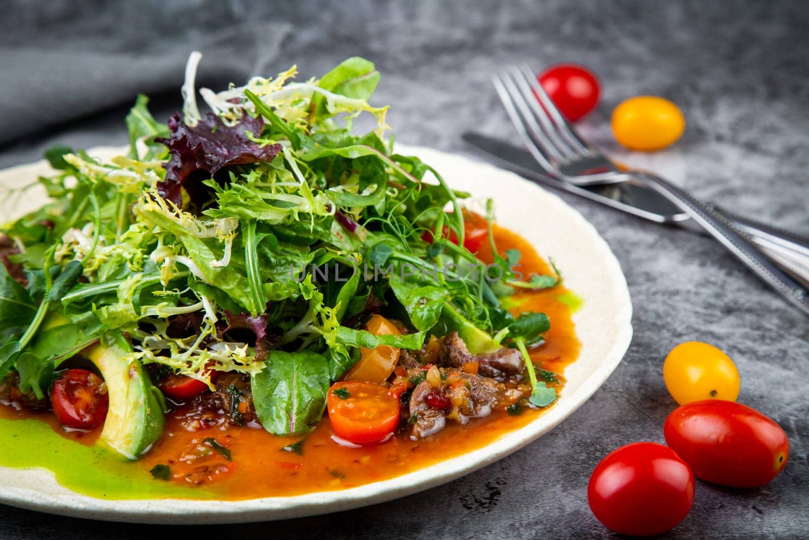 meat gravy with meat, cherry tomatoes and a bunch of greens on top, side view by tewolf