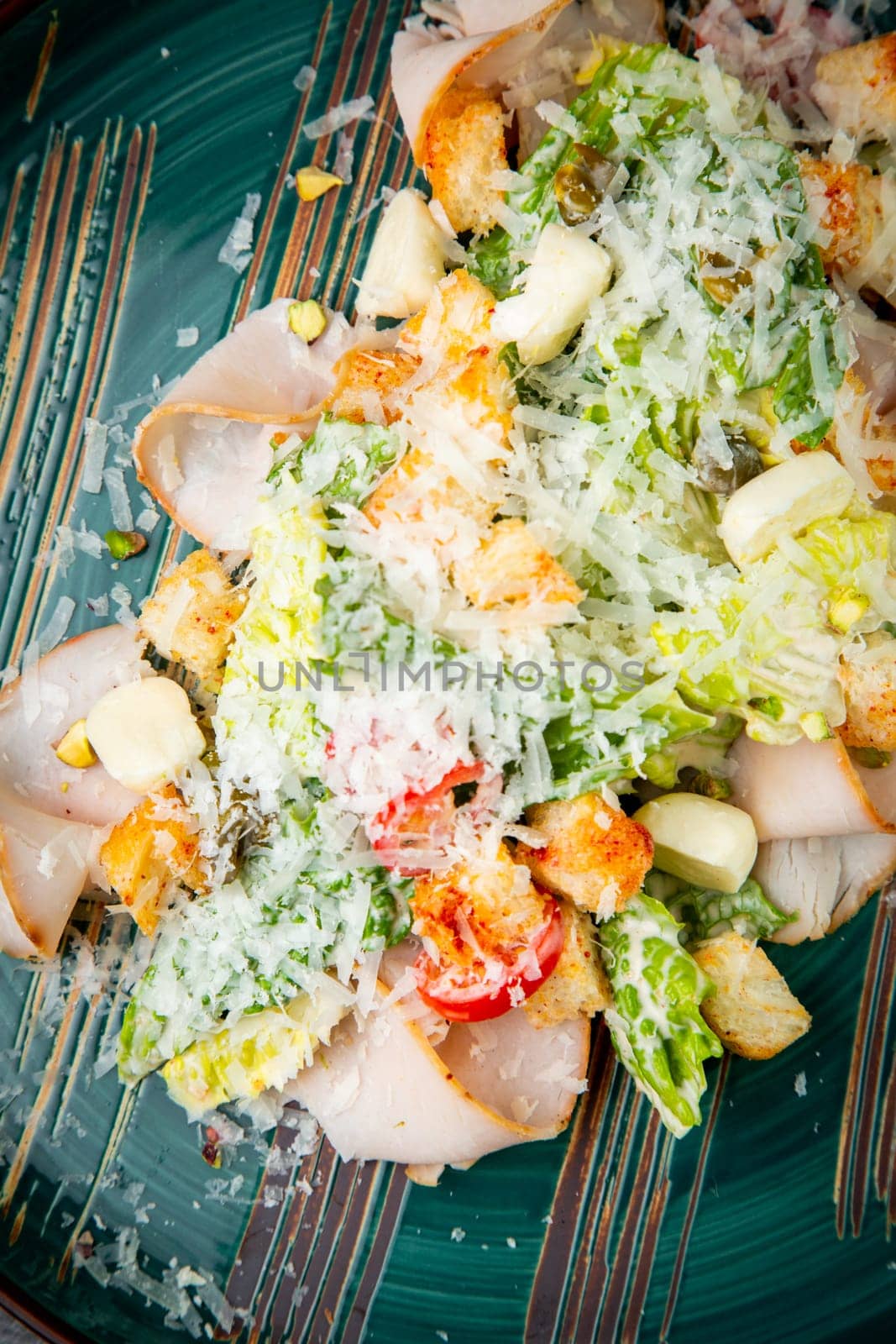 caesar salad with cheese on a blue plate. High quality photo