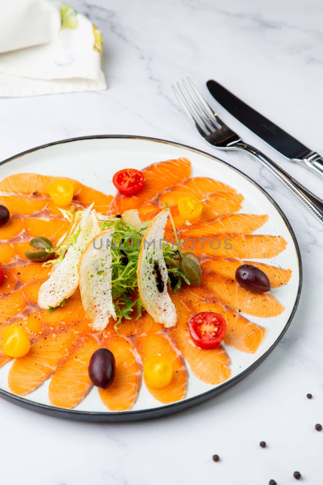 Sliced red fish slices with herbs, cherry tomatoes and white bread croutons. High quality photo