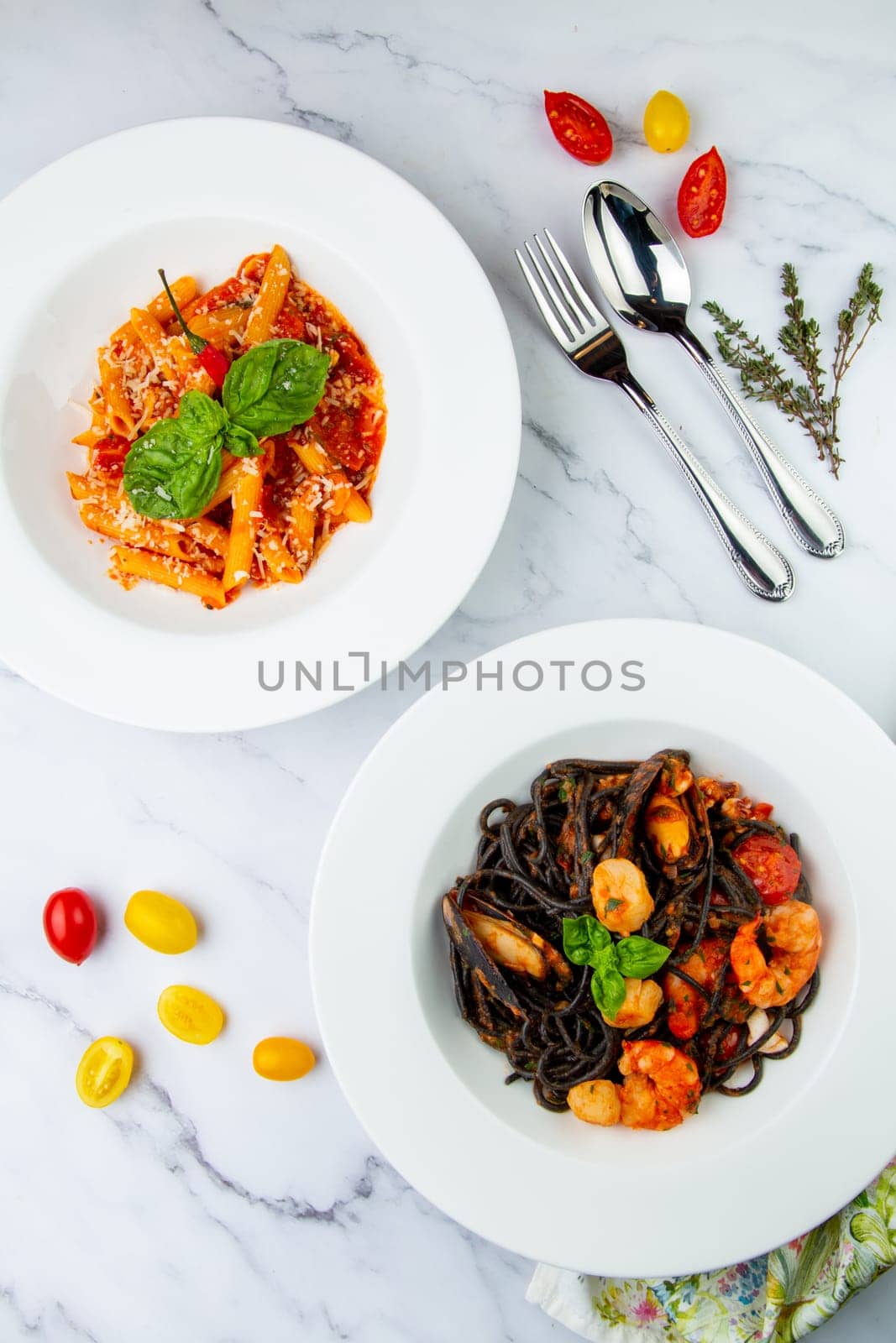 black noodles with mussels, shrimp, tomatoes and herbs side view by tewolf