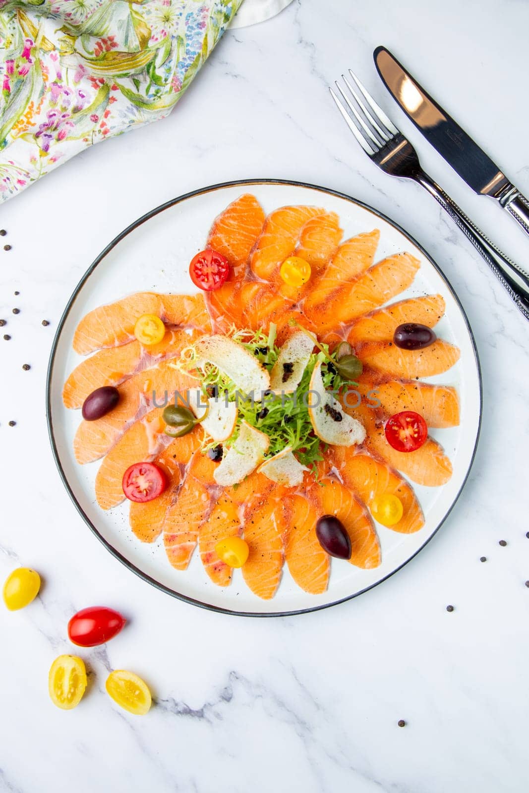 Sliced raw red fish, with white bread crumbs, herbs and cherry tomatoes. View from the top. High quality photo