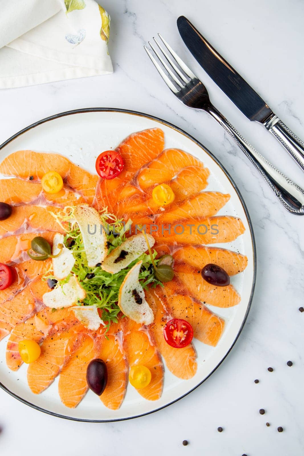 Sliced raw red fish, with white bread crumbs, herbs and cherry tomatoes. View from the top by tewolf