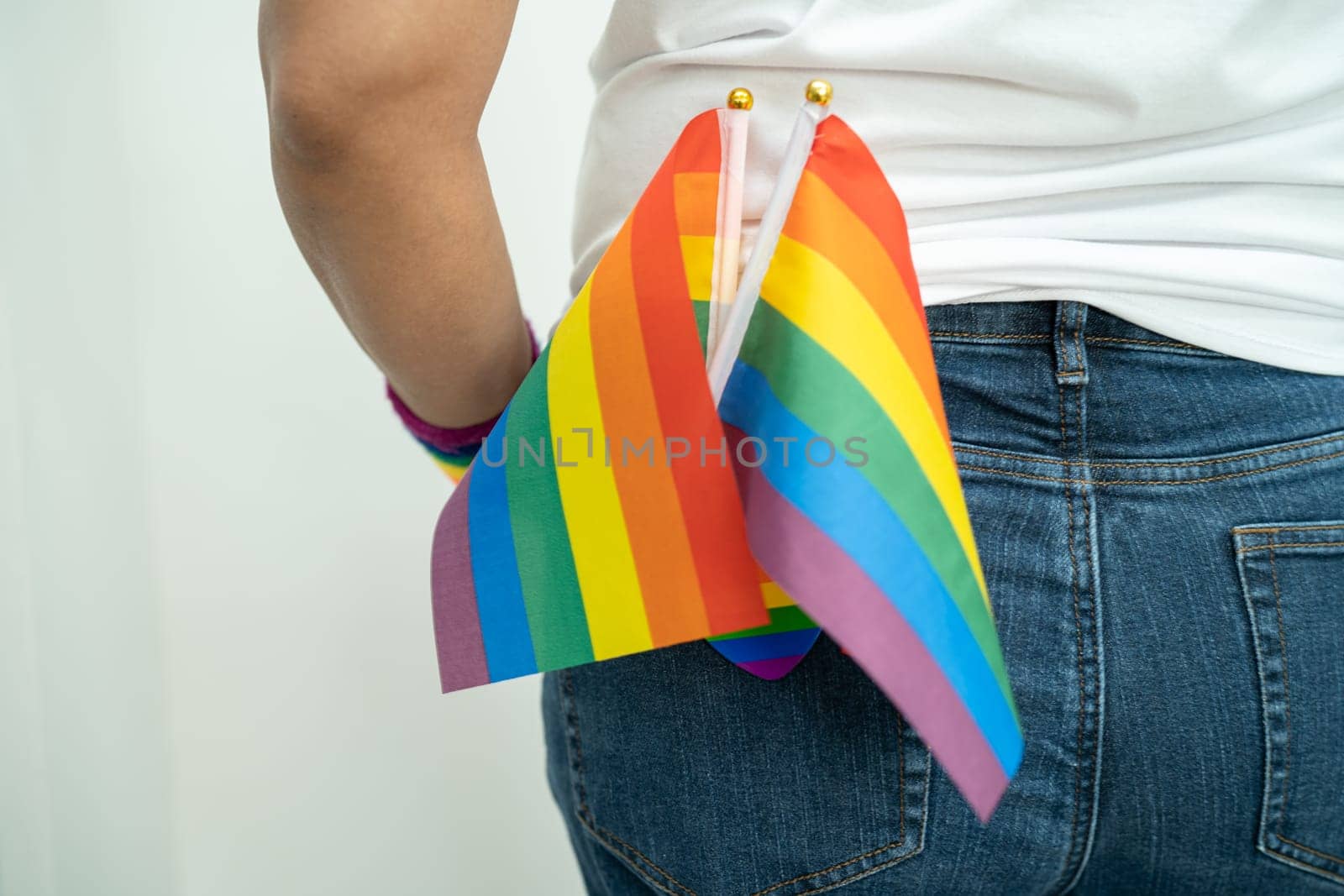 Woman holding LGBT rainbow colorful flag, symbol of lesbian, gay, bisexual, transgender, human rights, tolerance and peace.