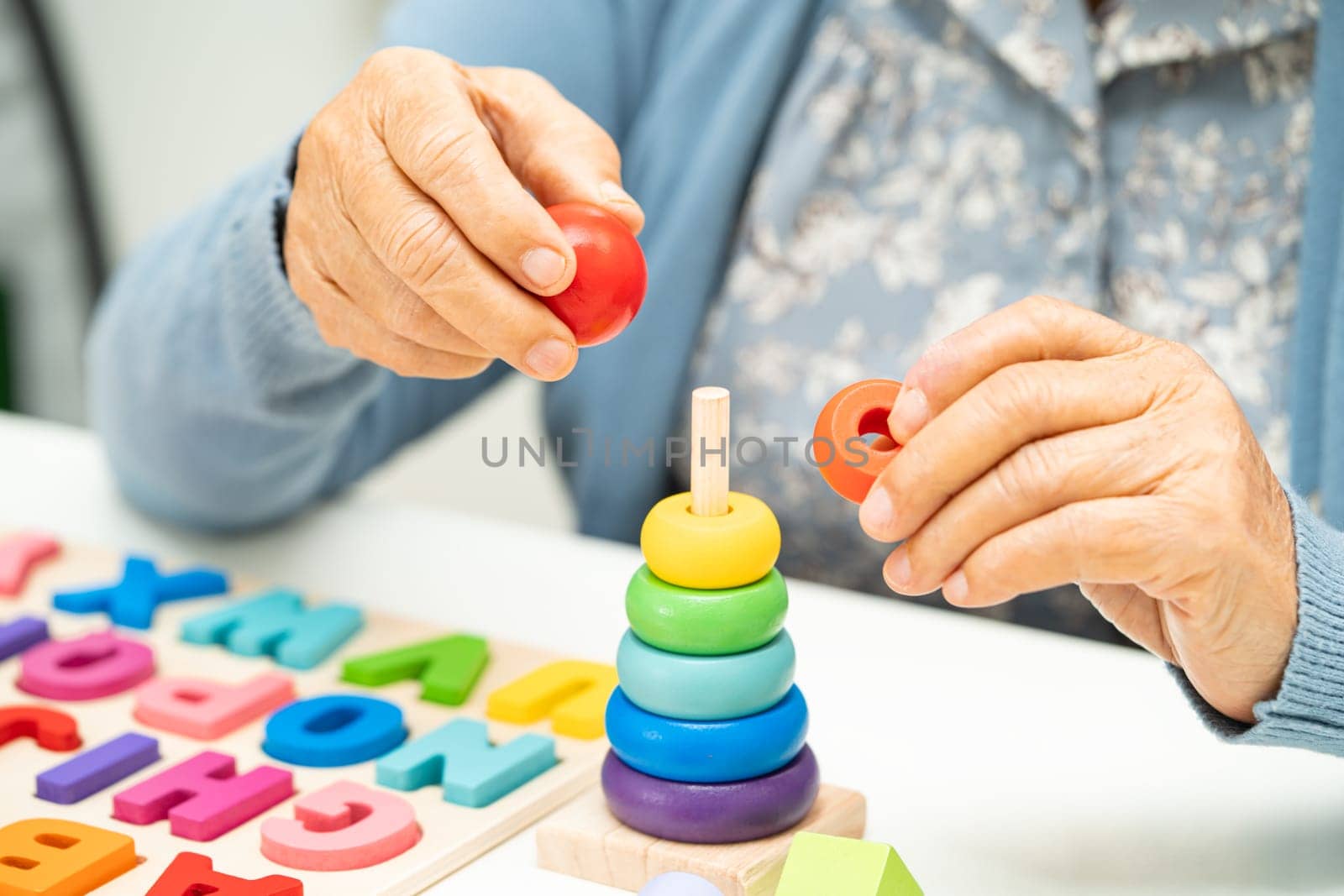 Alzheimer disease AD, Asian elderly woman patient suffering from dementia learn practical motor skills rehabilitation.