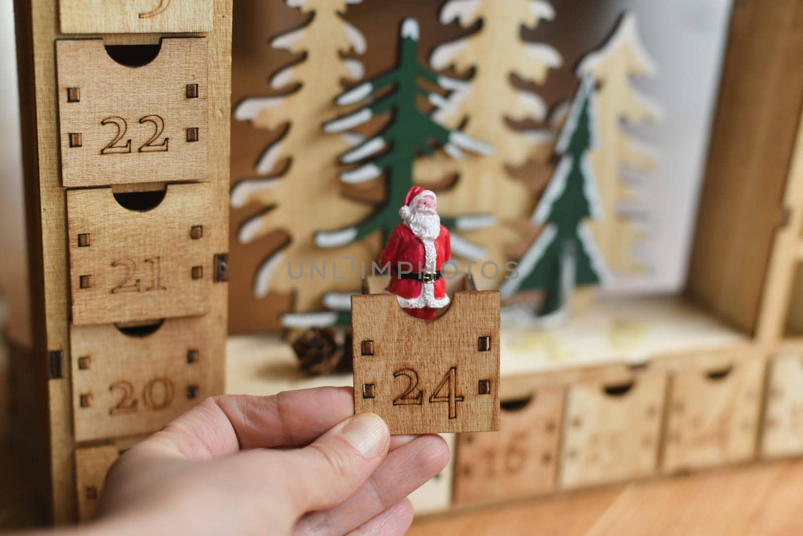 Hand opens wooden advent calendar