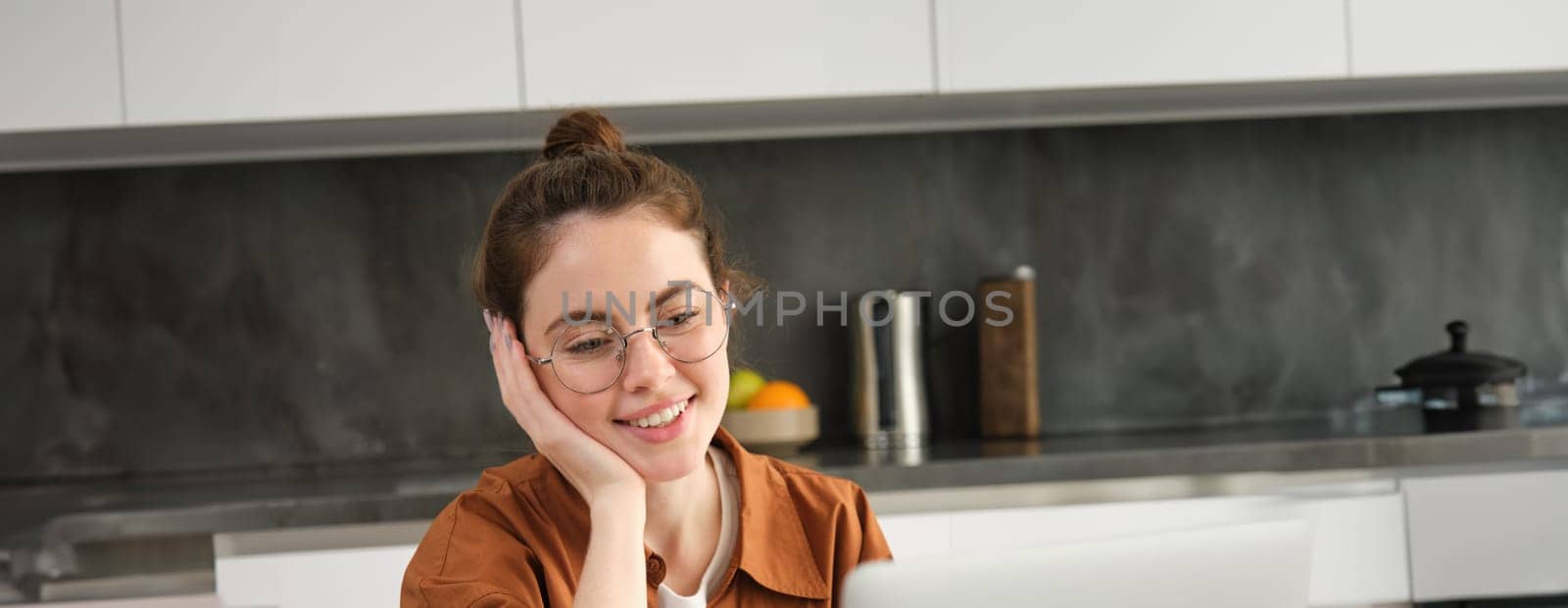 Vertical shot of young freelancer, woman working from home, typing on laptop, looking at screen by Benzoix