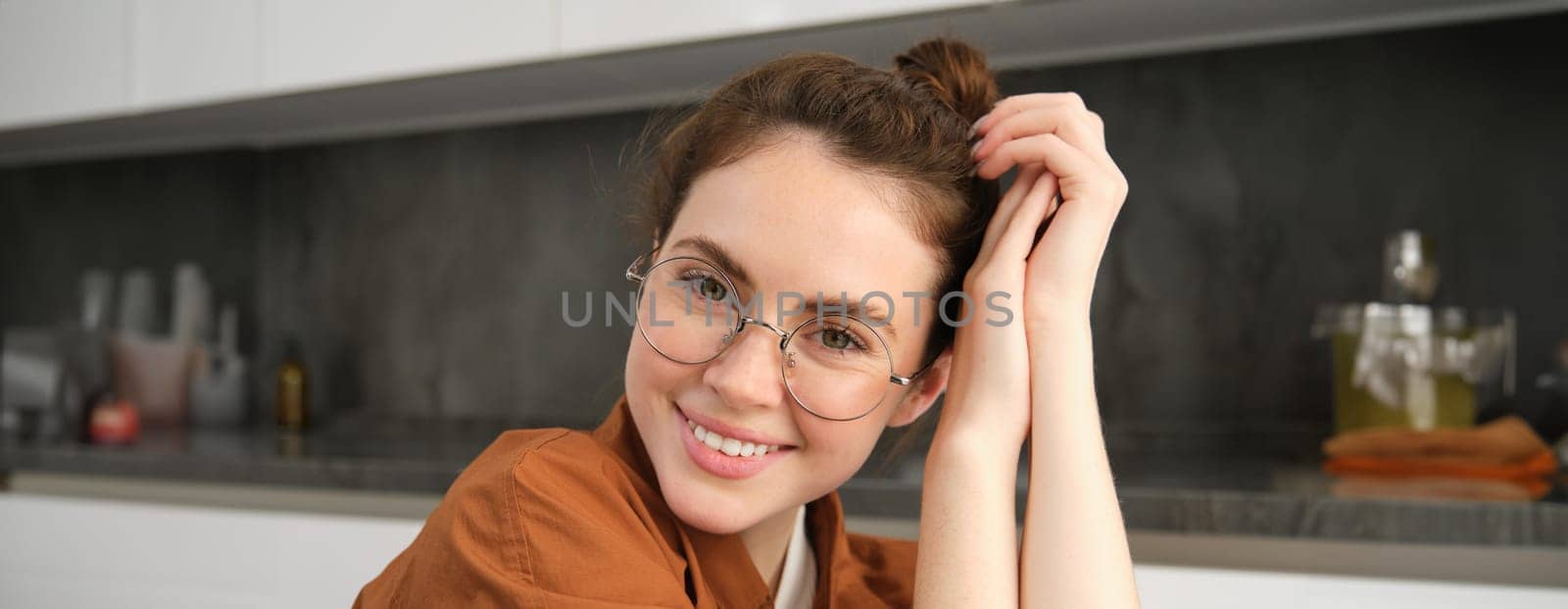 Portrait of gorgeous young woman in glasses, with happy smile, looking cute and tender, concept of modern people lifestyle.