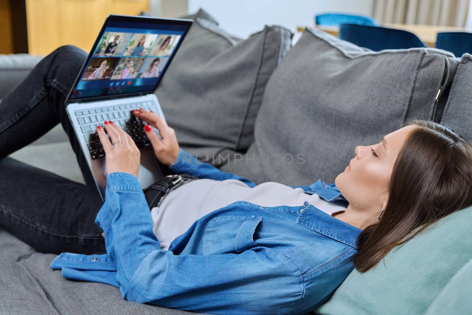 Laptop screen with online video conference by group of teenage students, young female in home talking to students. Education, wireless technology, e-learning, virtual lessons, distance learning