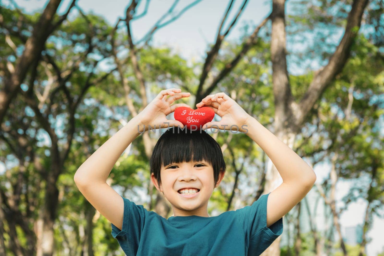 Eco awareness campaign promoting environmental protection with happy asian boy holding heart as symbol of love for nature and ecology for future greener sustainable Earth. Gyre