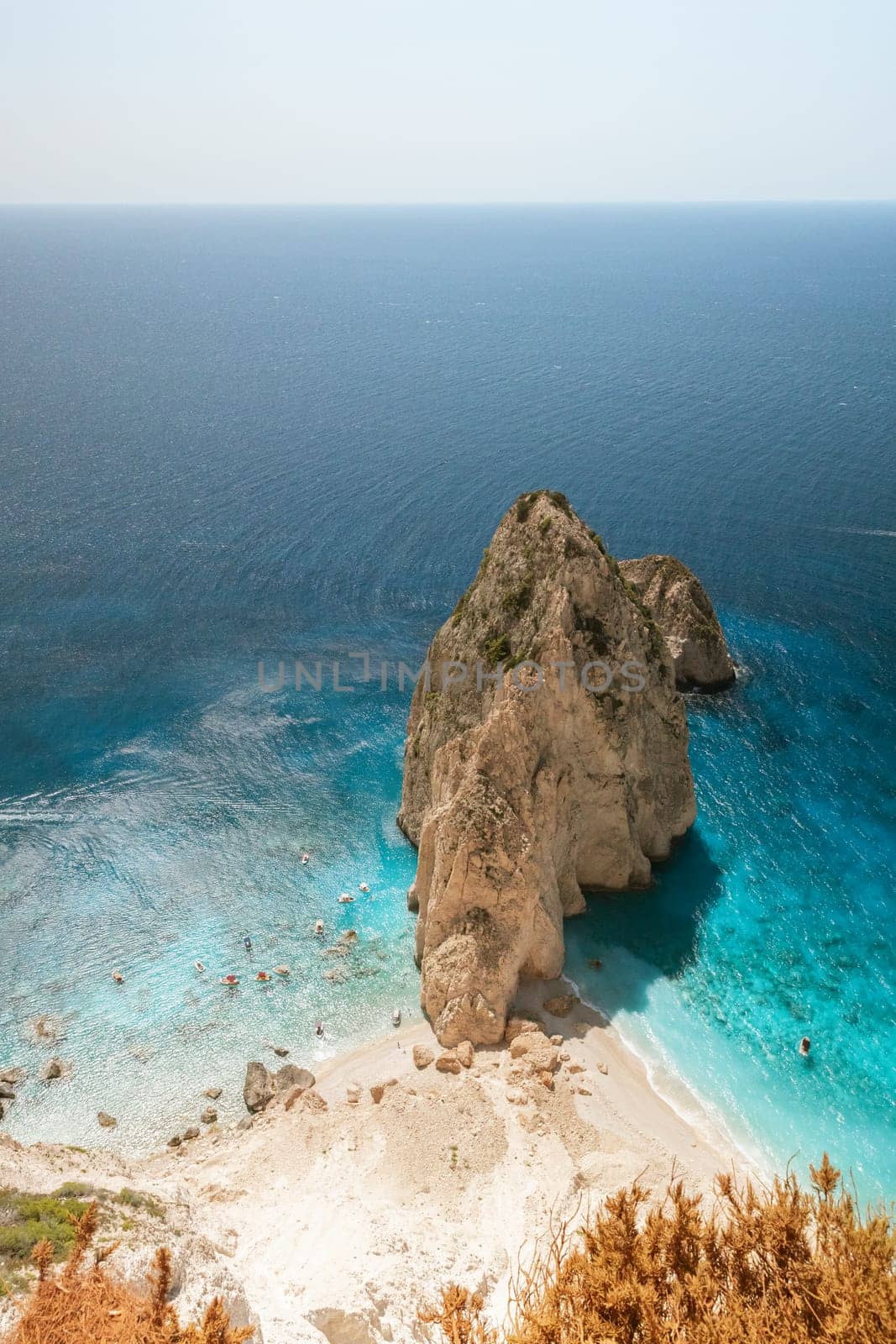 A beautiful view of one coastal cliff with the blue sea on a sunny summer day, view from above from a cliff, close-up.