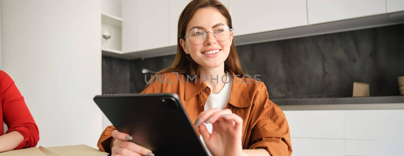 Portrait of beautiful brunette woman in glasses, freelancer working from home, girl studying in her kitchen on distance education, joins online course.