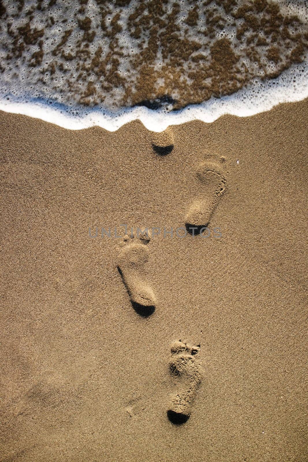 Photographic documentation footprints of people on gray sand 
