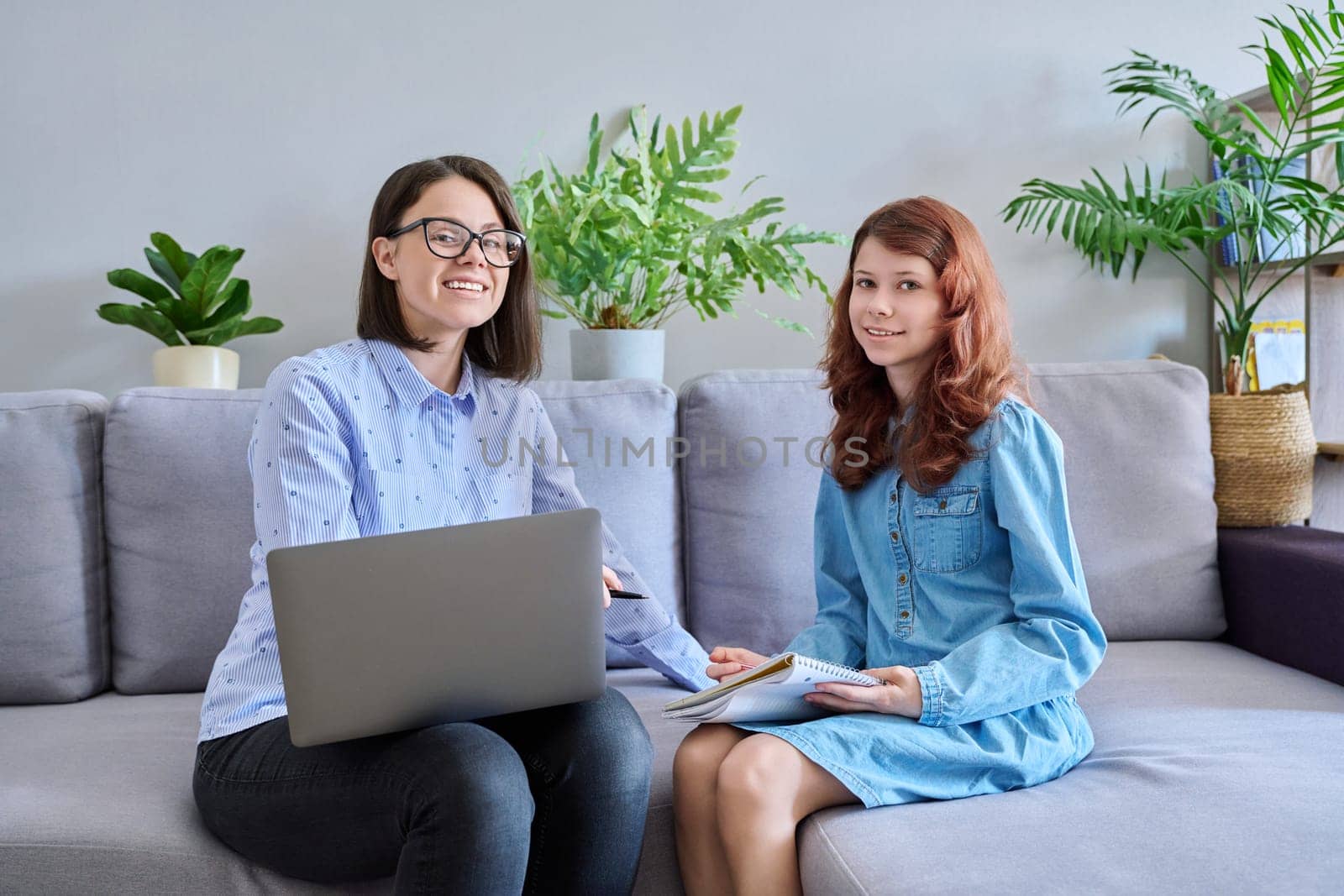 Individual lesson of teacher and child of preteen girl. Young woman teaching child, using laptop, student makes notes in notebook. Knowledge, education, teaching, tuition, school childhood concept