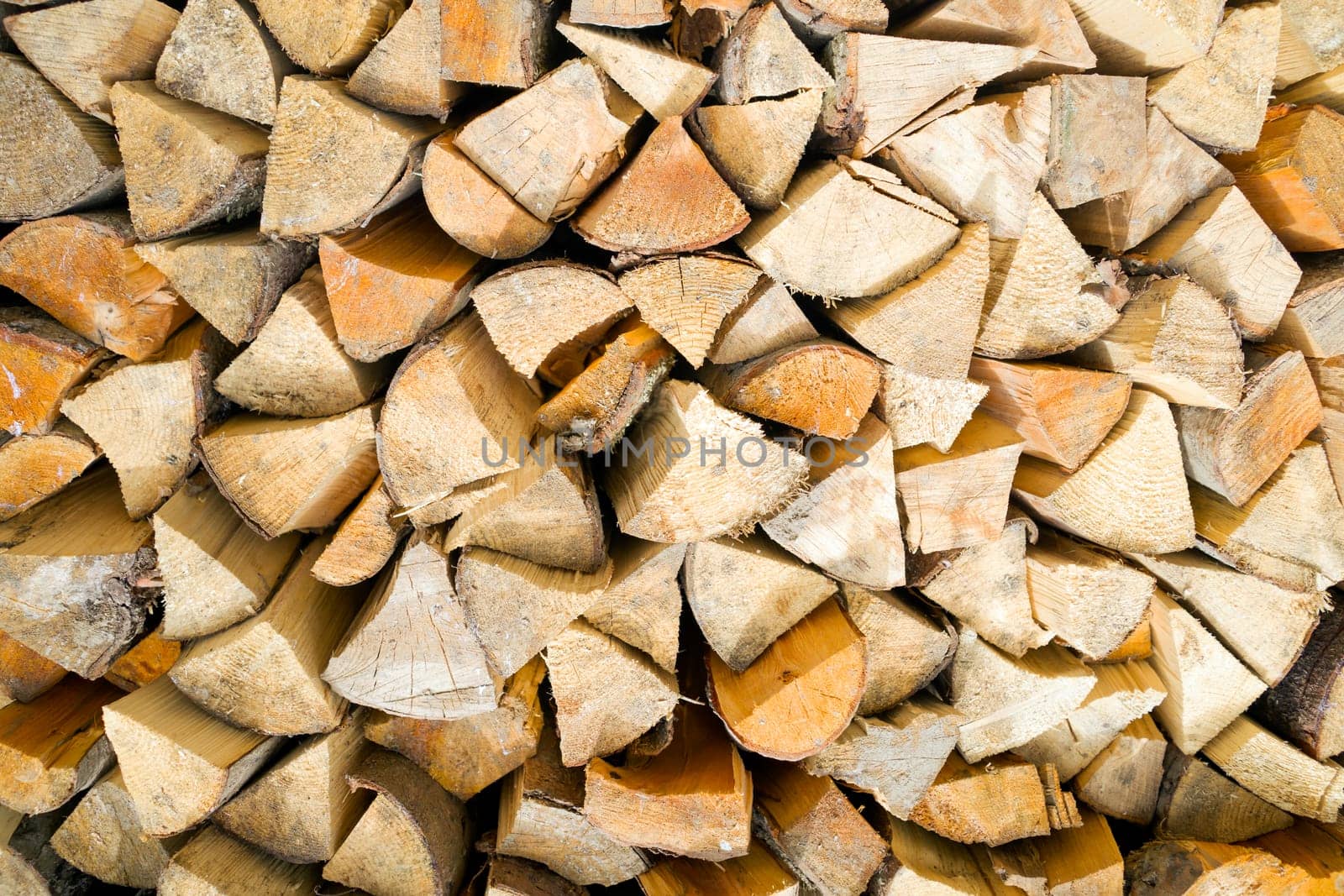 Old tree, logs, firewood harvested for the winter for the heating season, a beautiful background with textured wooden boards close-up.